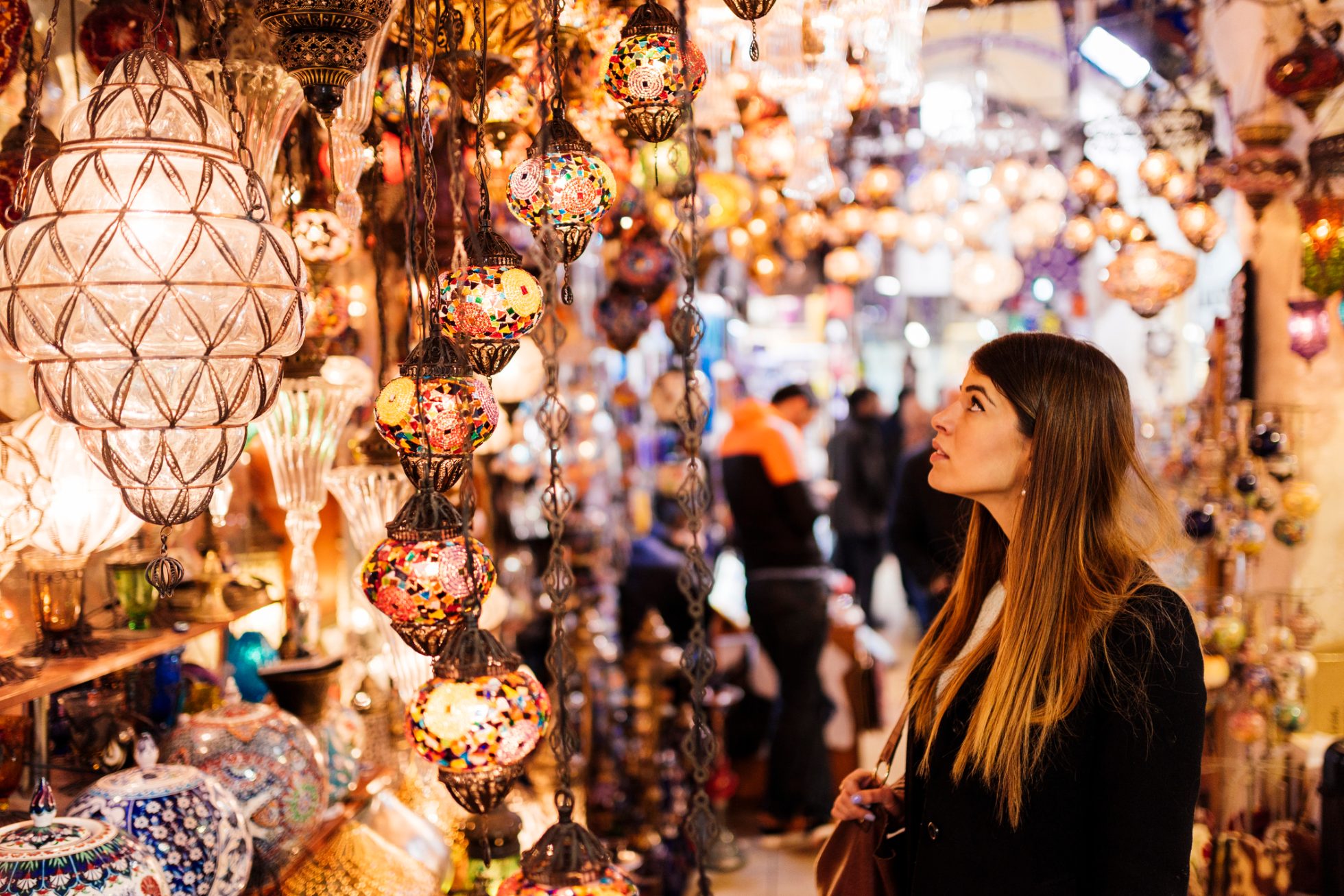 Young woman looking at lights on market stall, Istanbul, Turkey