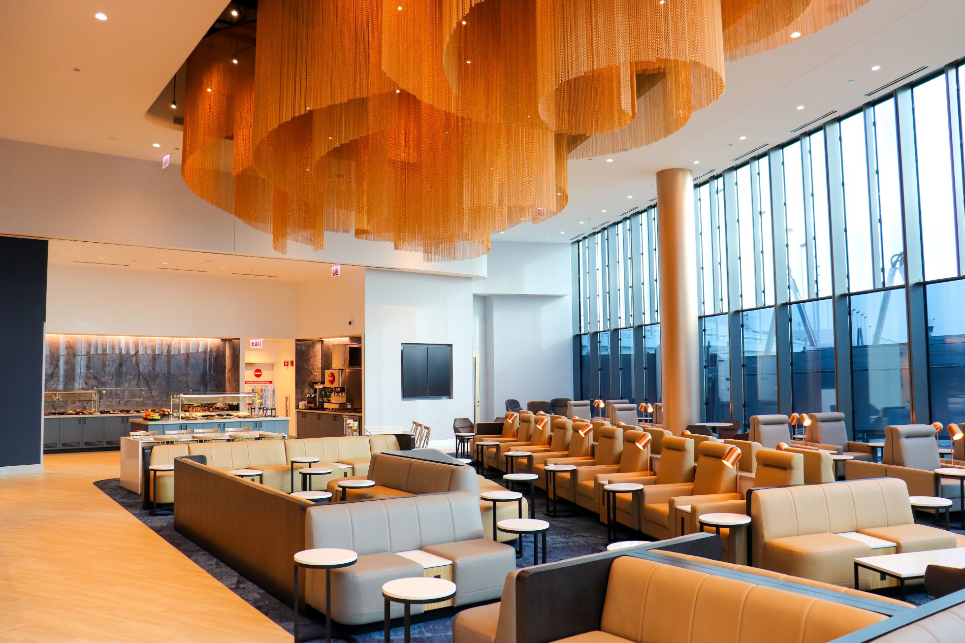 View of the spacious area in the Business Lounge in Chicago, modern interior, stylish light sofas, and round tables