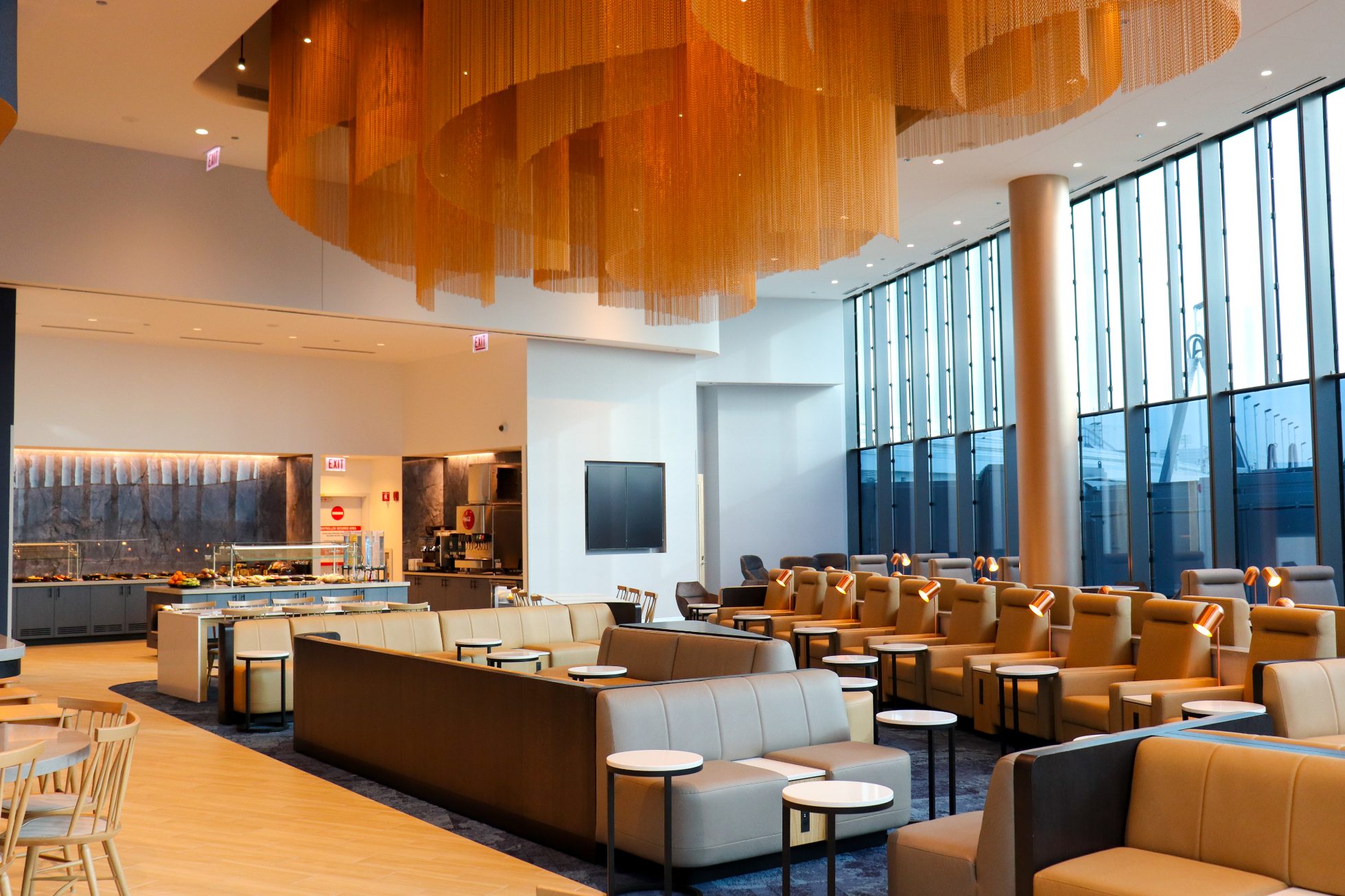 Bright, elegant Chicago Business Lounge view: comfortable armchairs, sofas, round tables, interesting ceiling lighting.