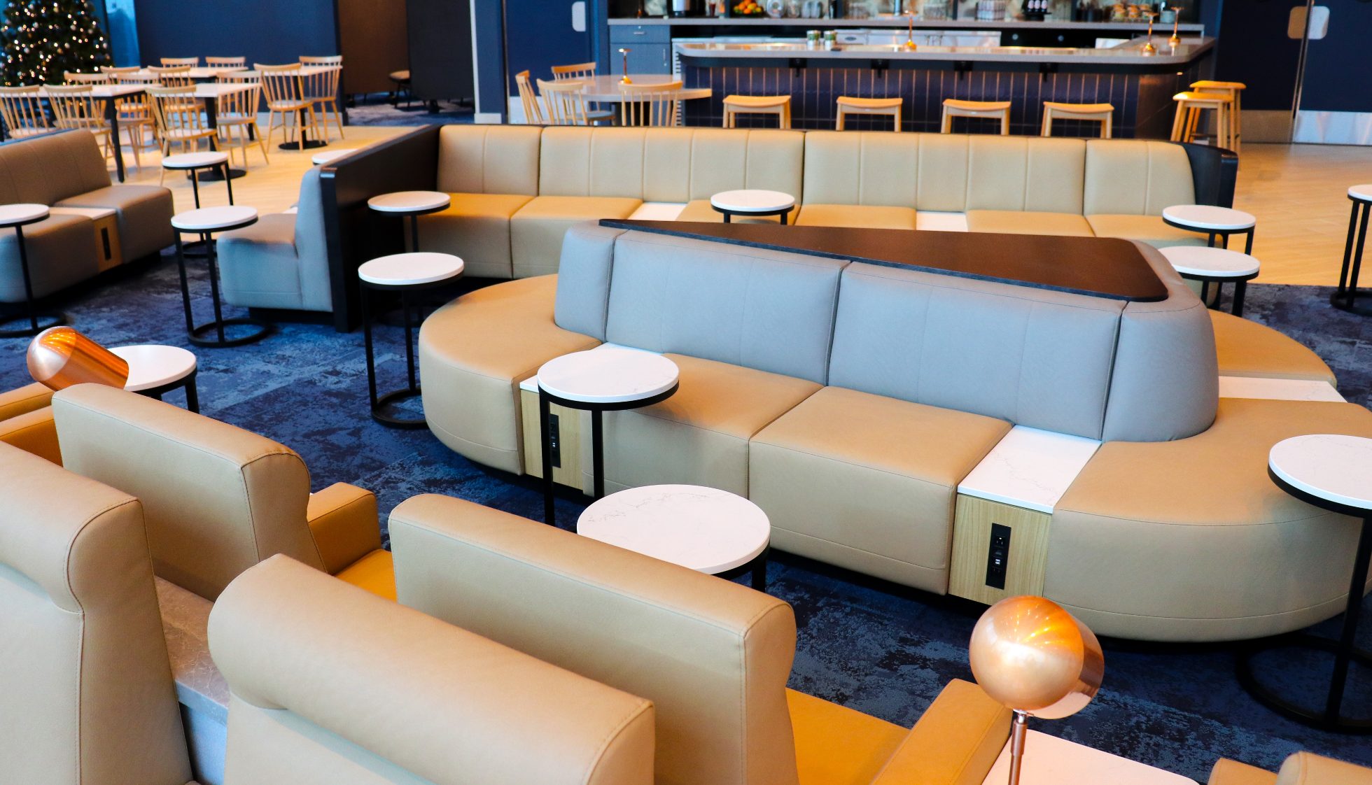 View of the spacious area in the Business Lounge in Chicago, modern interior, stylish light sofas, and round tables