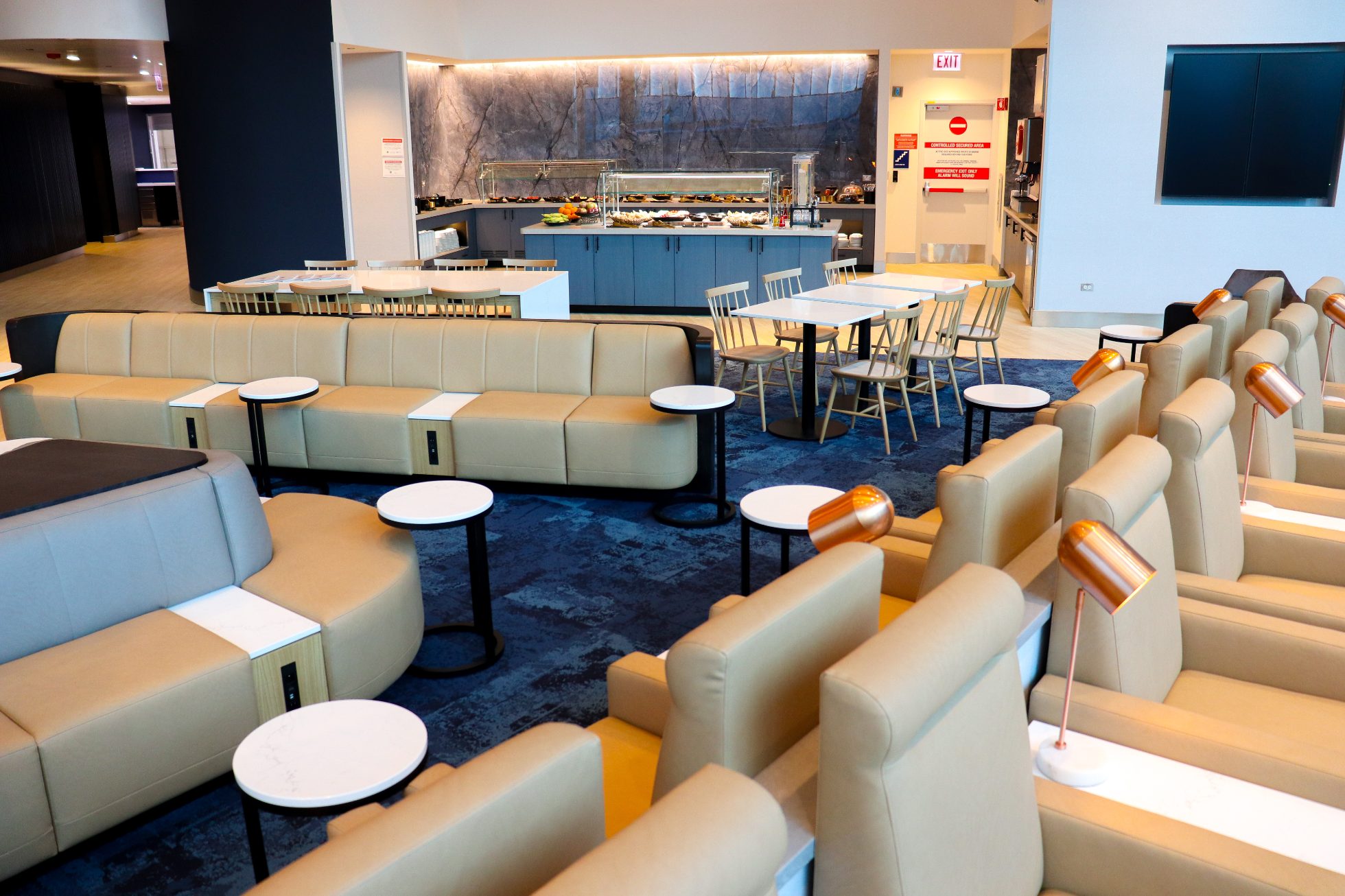 Elegant Business Lounge at Chicago Airport - overhead view showing comfortable sofas and armchairs with round tables and navy blue carpet
