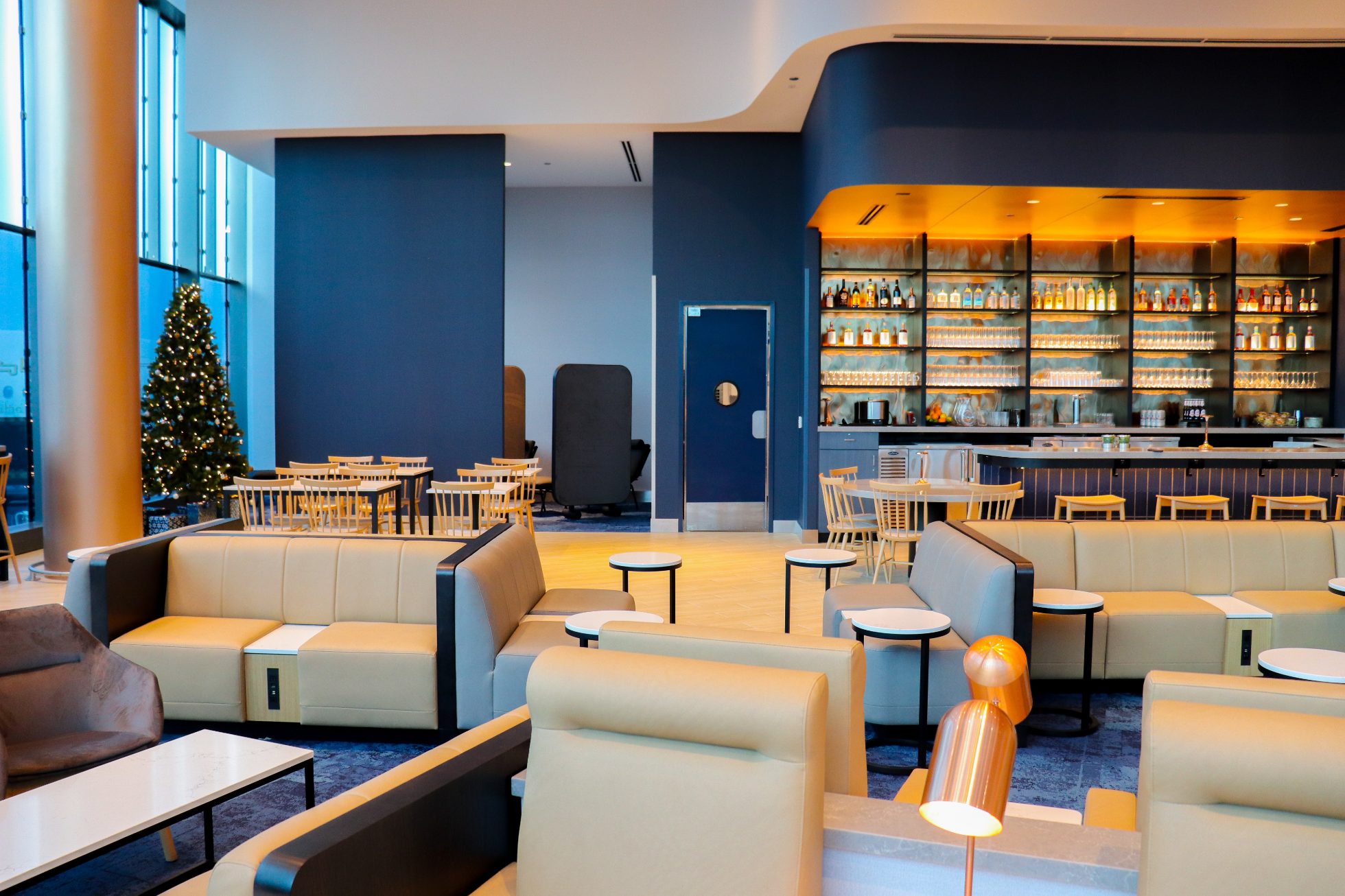 View of the spacious area in the Business Lounge in Chicago, modern interior, stylish light sofas, and round tables
