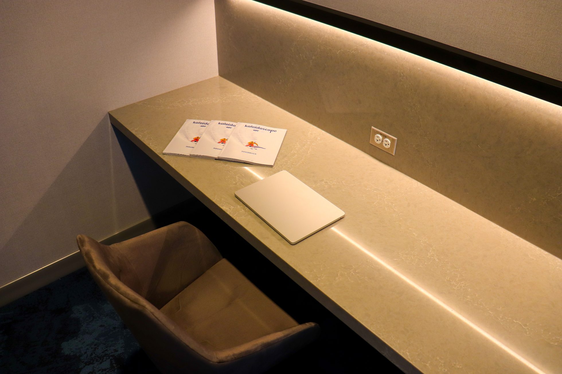 Marble table with Kaleidoscope magazines and a laptop on it in the Chicago Lounge