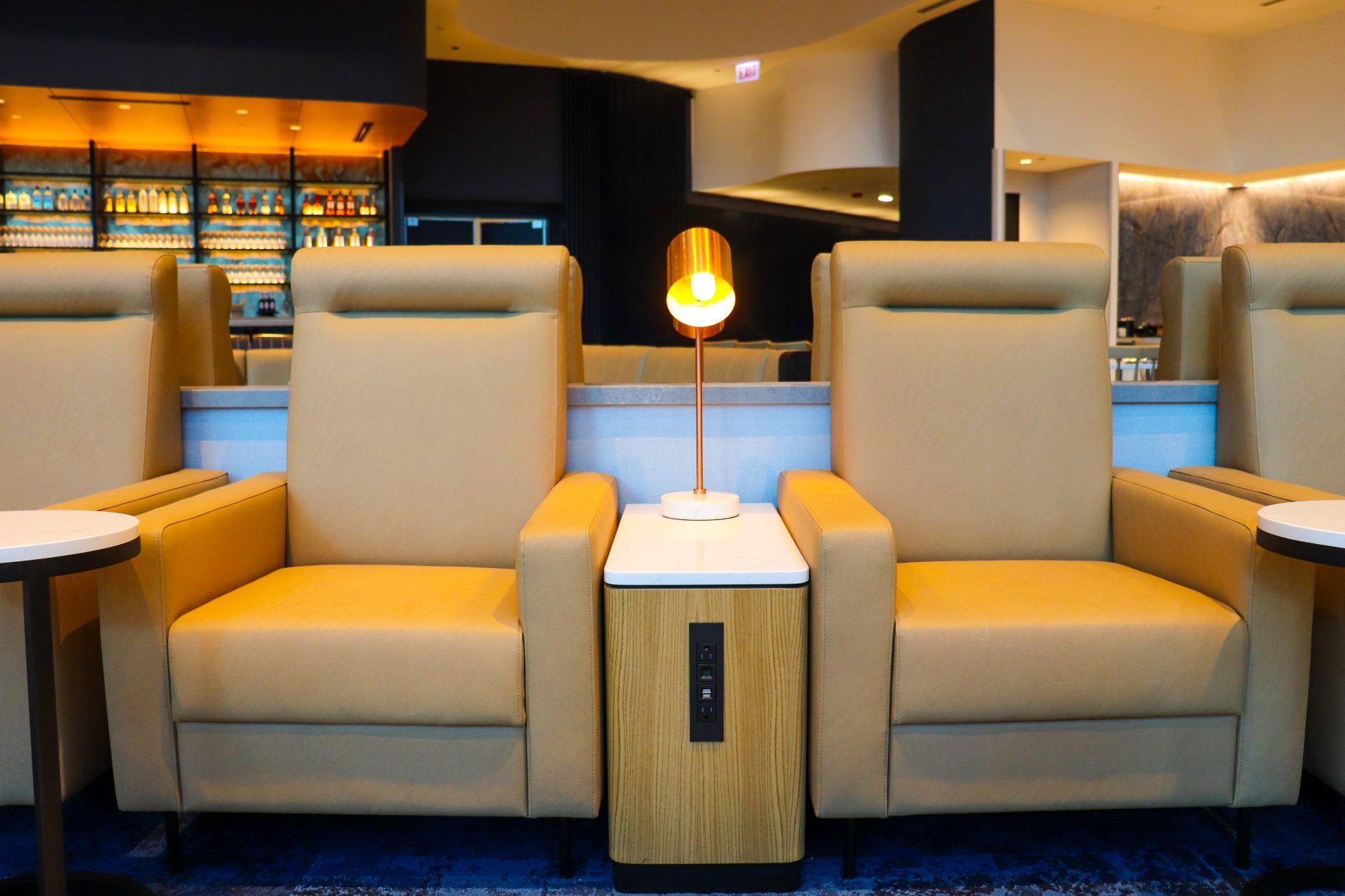 Two elegant beige armchairs with power outlet panel in Chicago business lounge