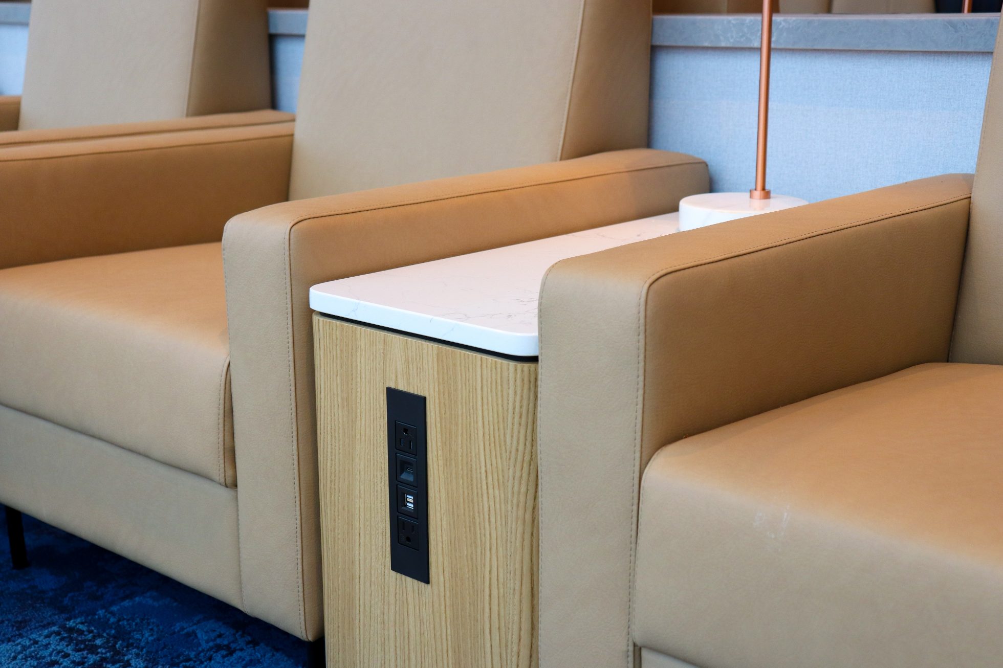 Two elegant beige armchairs with power outlet panel in Chicago business lounge