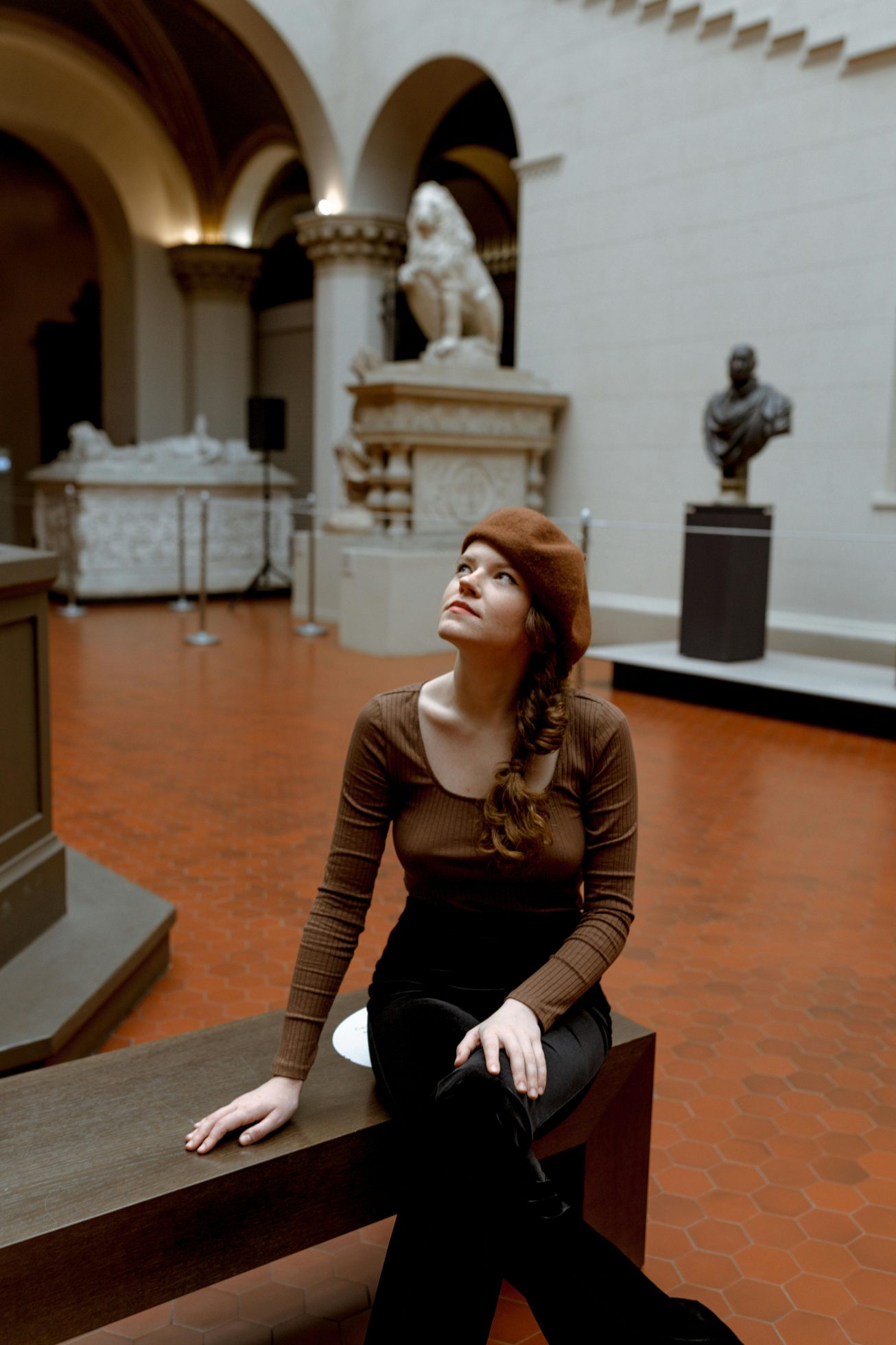 Young woman explores museum, viewing exhibits.