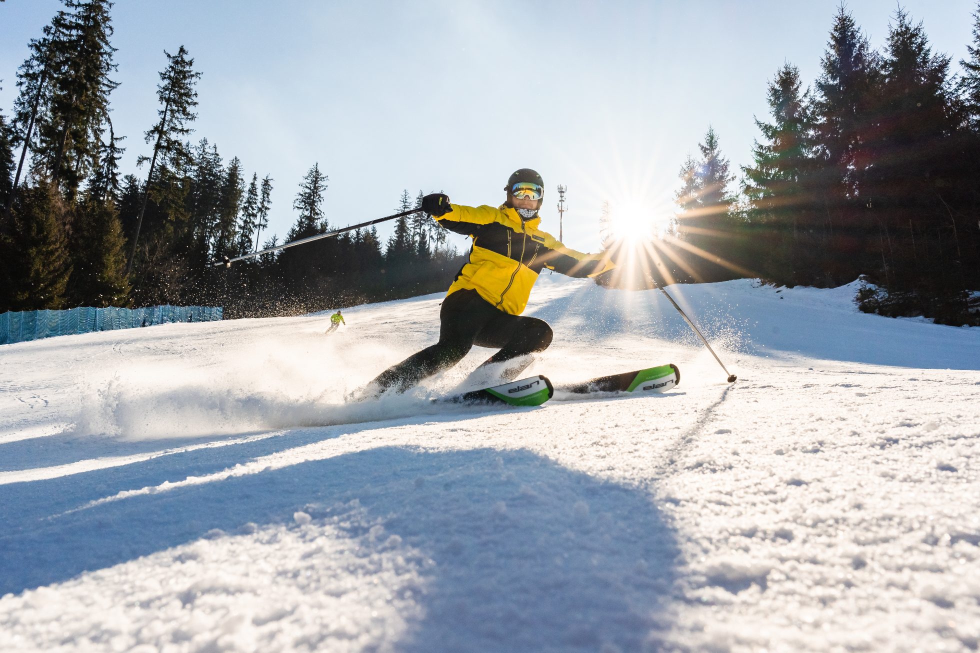 A skier in a yellow jacket descends a ski slope in Czechia