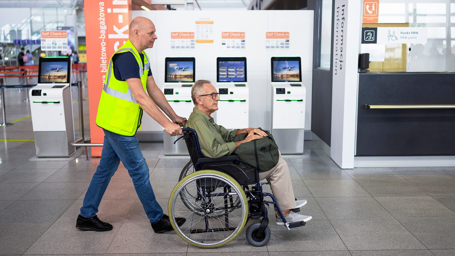Ground staff assist the passenger with a wheelchair.