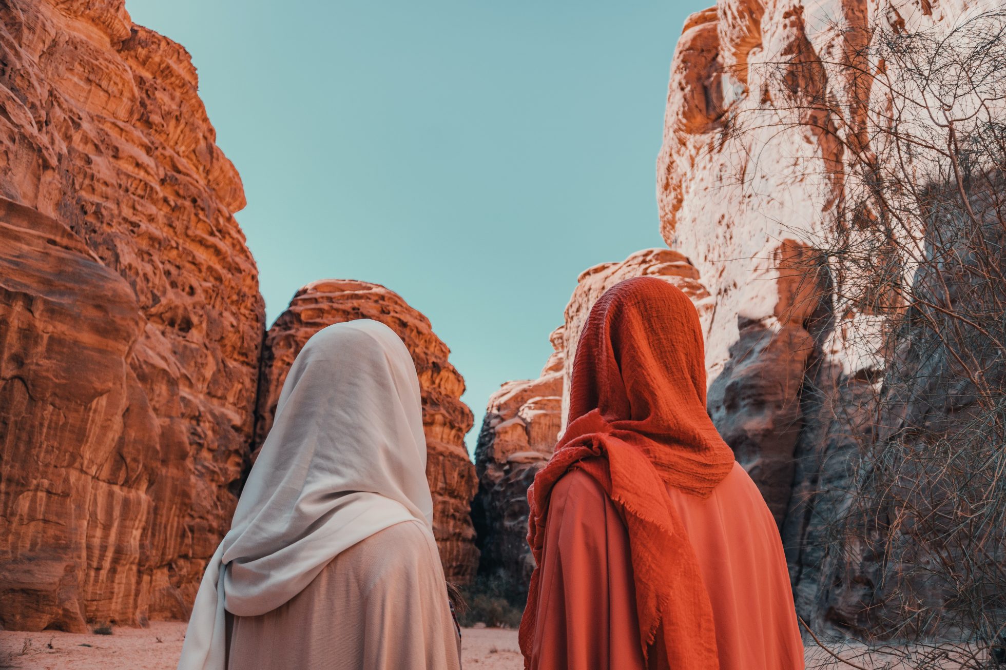Kobiety w tradycyjnych strojach spacerują po pustyni Hisma w Arabii Saudyjskiej.