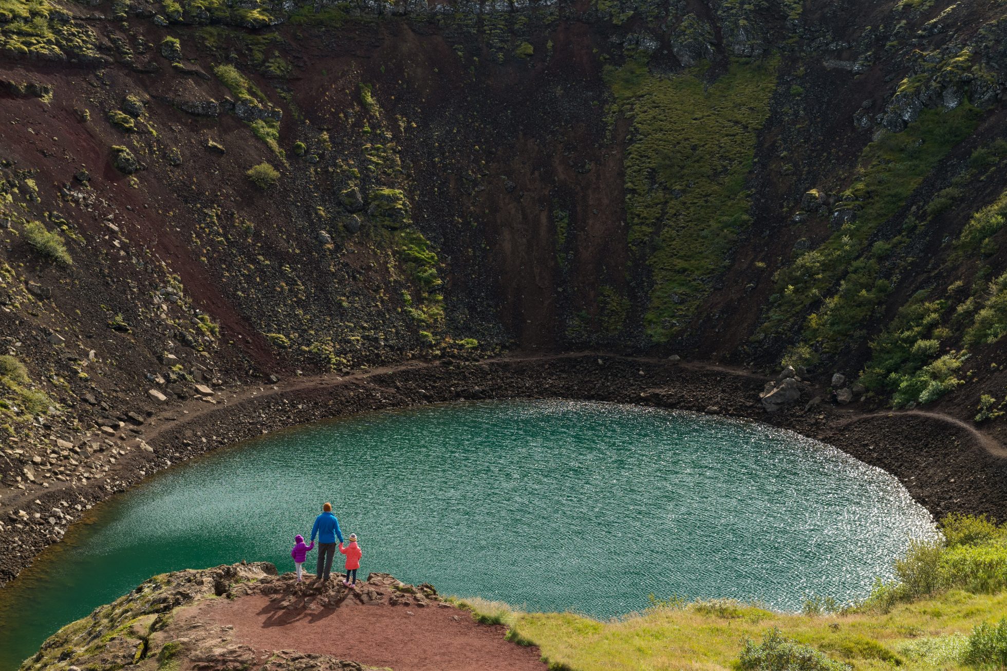 View of people standing at Lake Kerid in Iceland