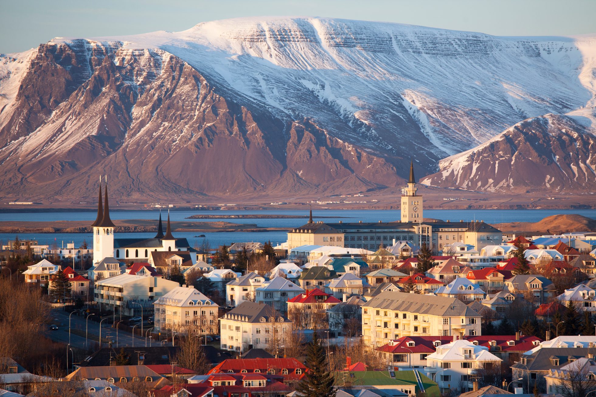 Widok na panoramę Reykjaviku z zatoką i ośnieżonymi górami w tle