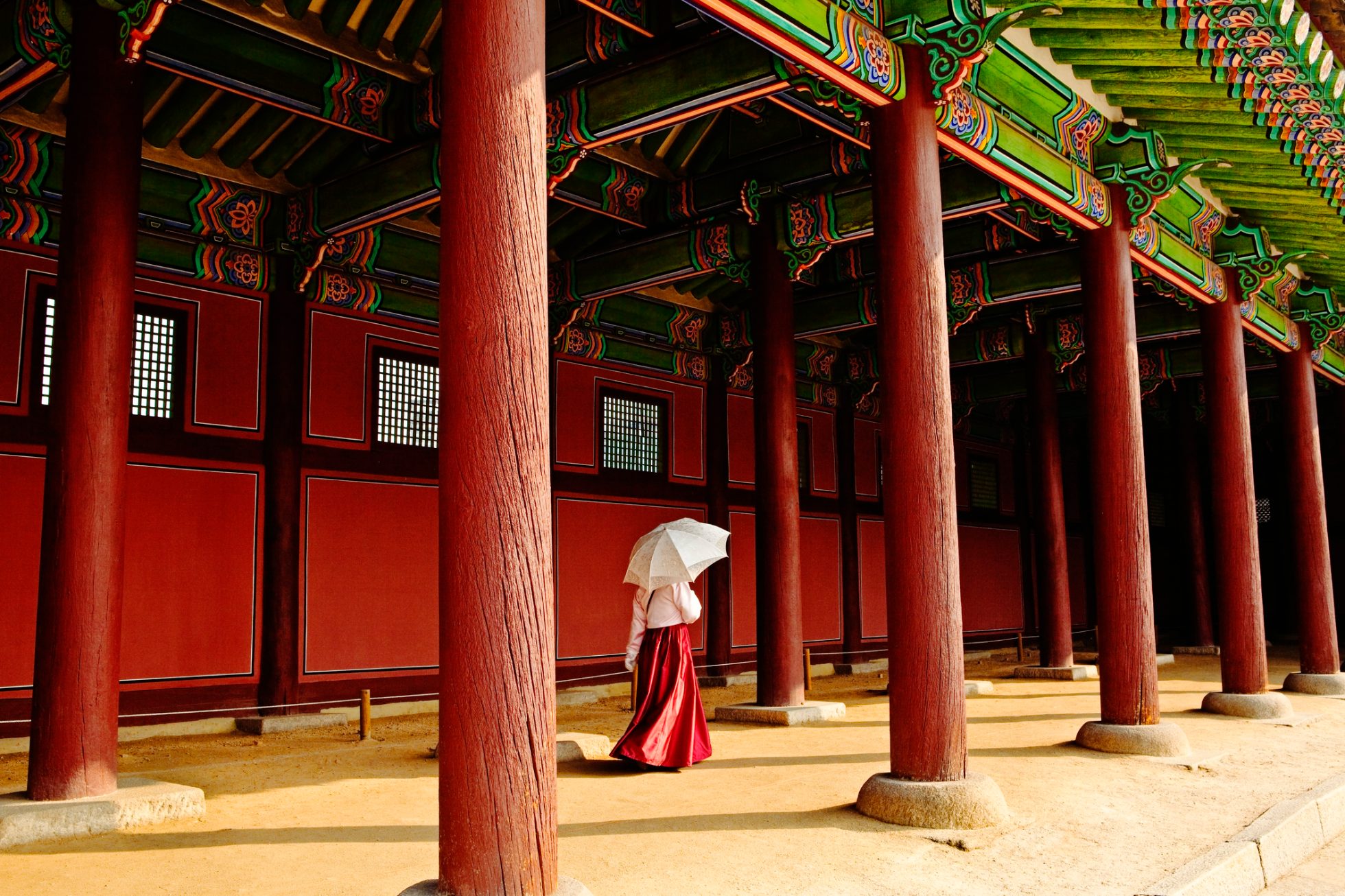Female Palace official walking with umbrella in Gyeongbokgung Palace in Seoul