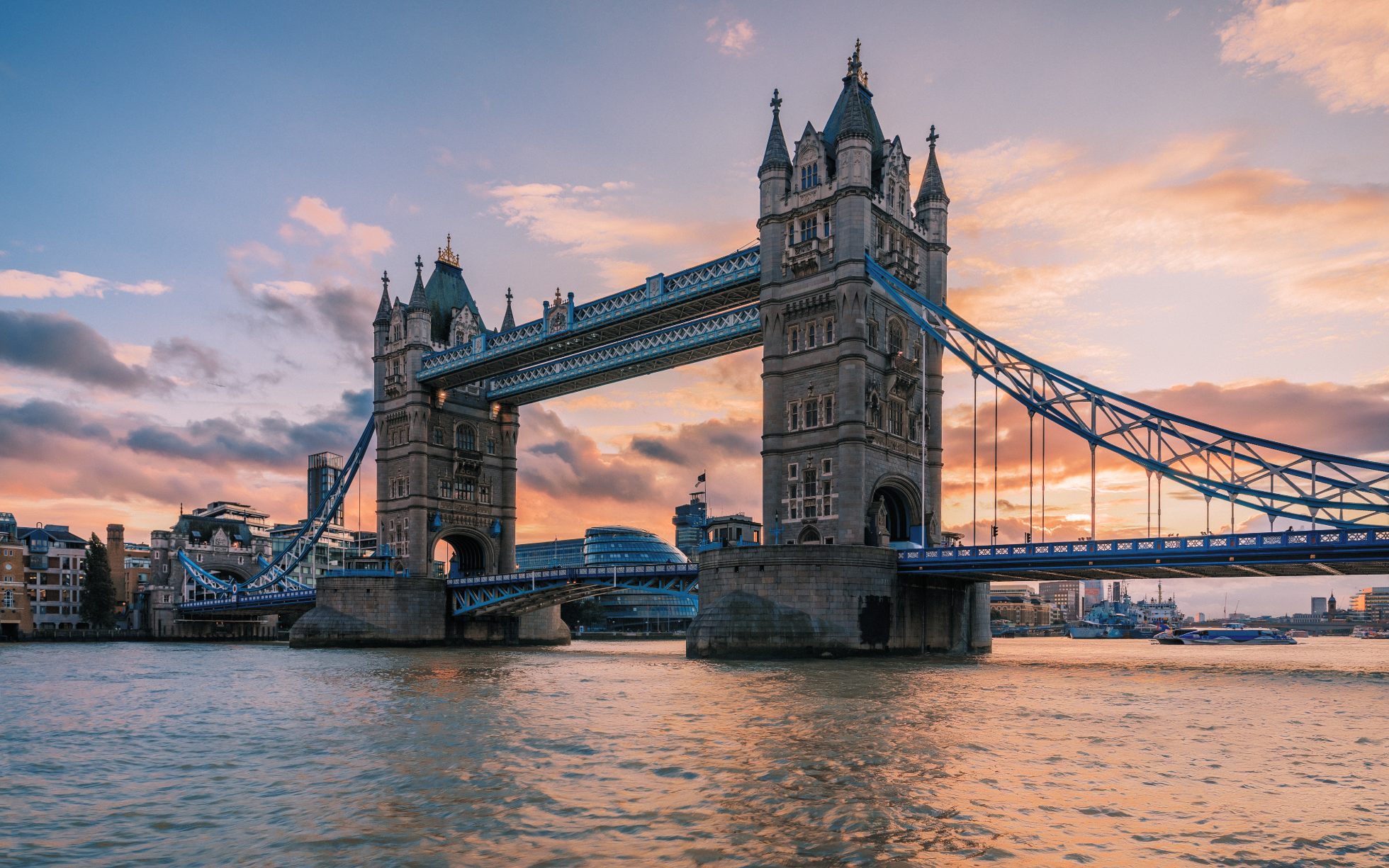 London's Tower Bridge on the Thames with characteristic lanterns and boats passing underneath.