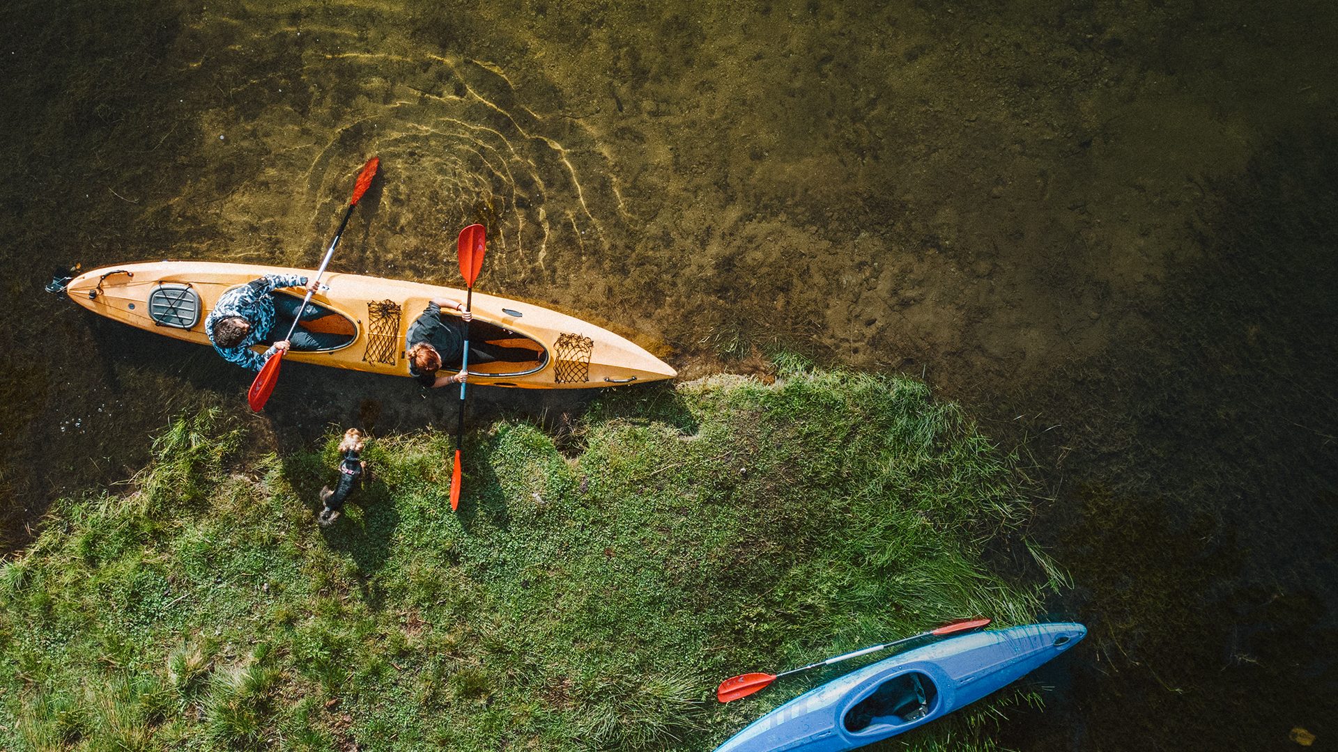 A man and a woman in a kayak on the shore of the lake - flights to Olsztyn