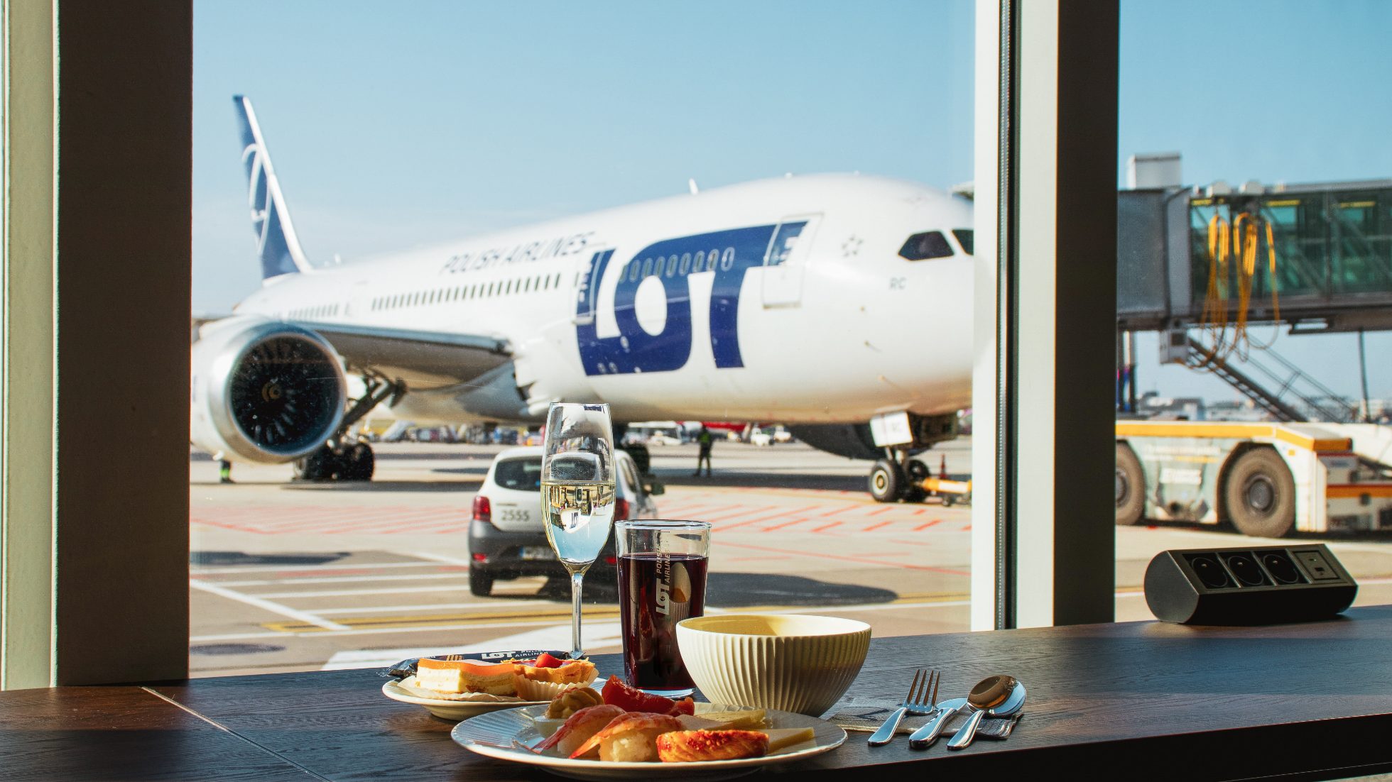 a meal with a view of LOT's Dreamliner standing on the tarmac