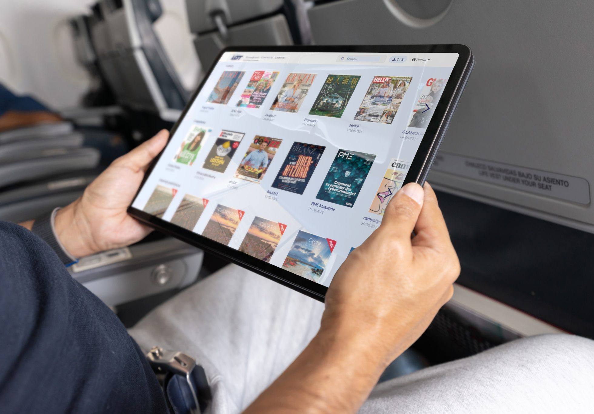 Close-up of a man traveling by plane and watching a movie on a tablet.