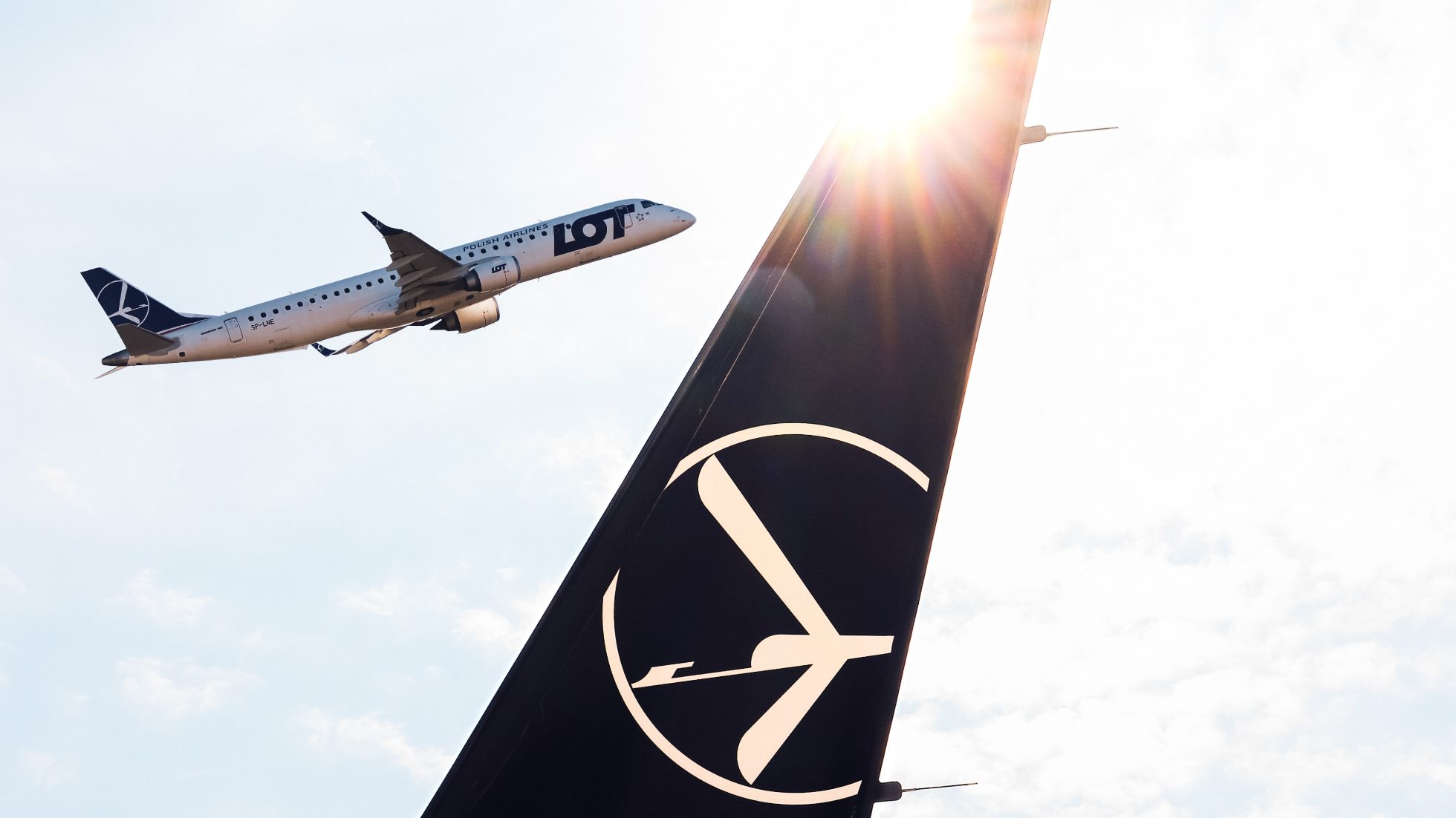 winglet samolotu Boeing 737 MAX 8 z logiem żurawia i startujący w tle samolot Embraer 190 PLL LOT w słoneczny dzień