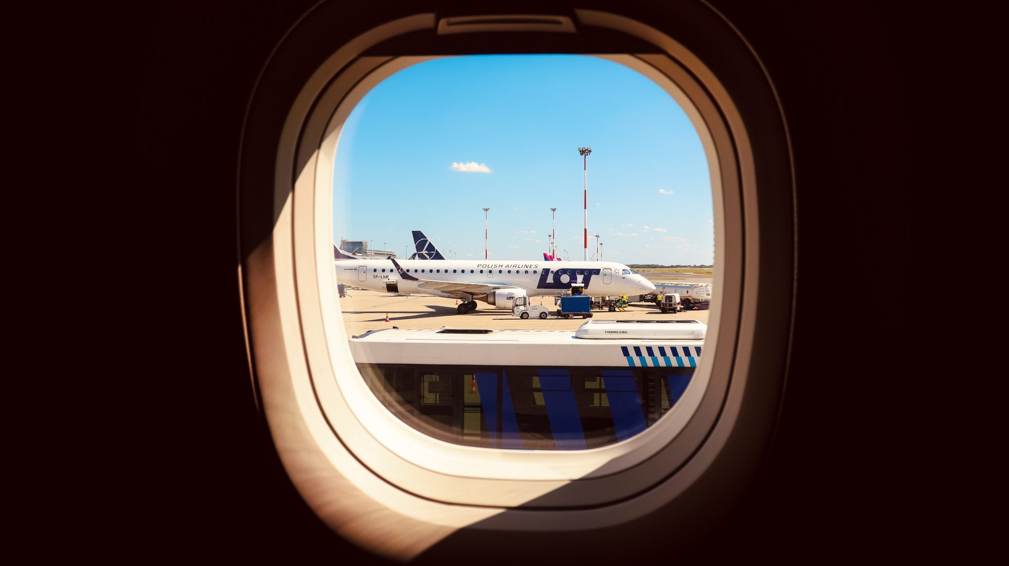 Embraer E2 aircraft window view of wing and sky.