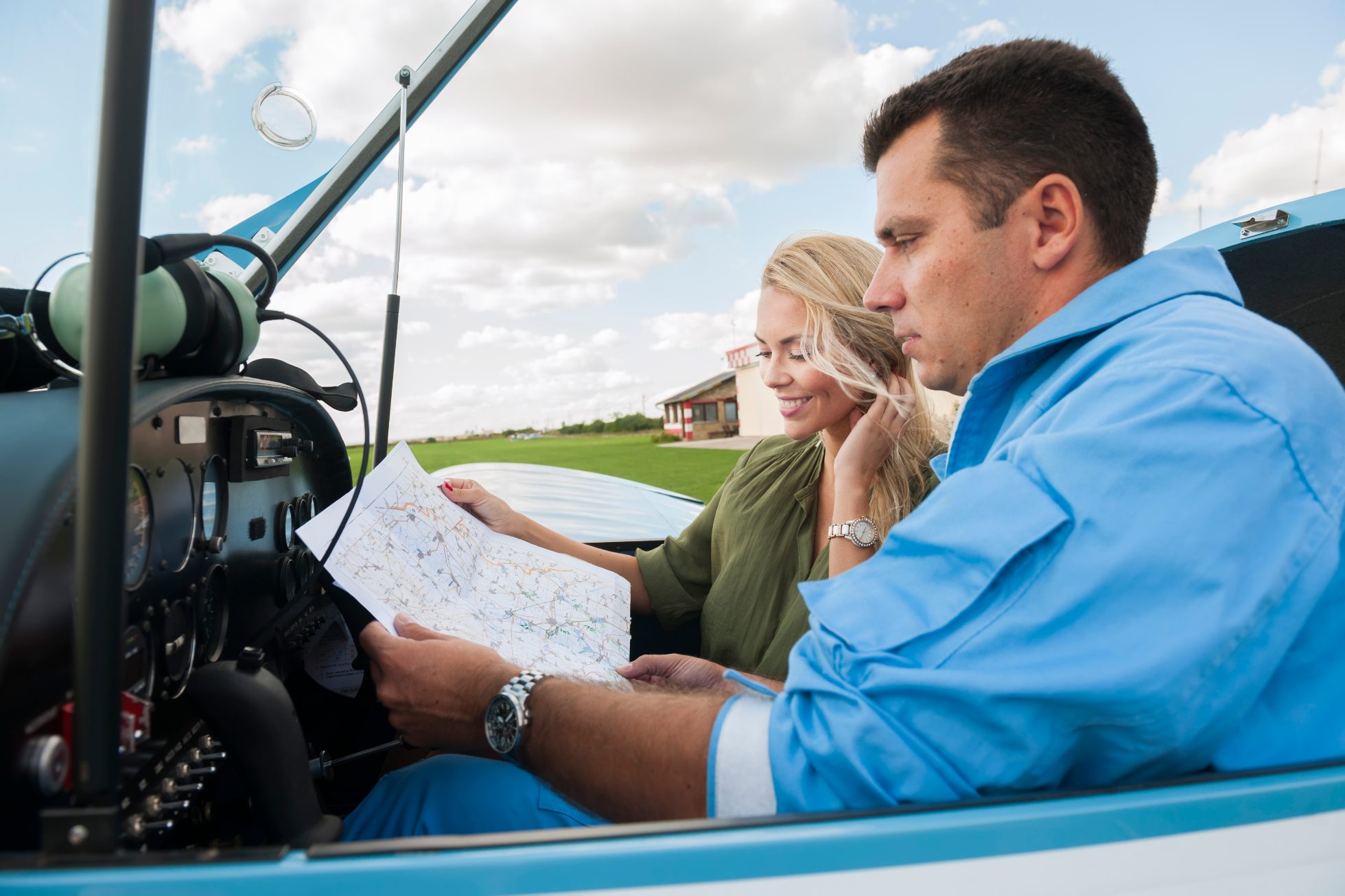 Woman and man pilot looking at map, preparing for flying