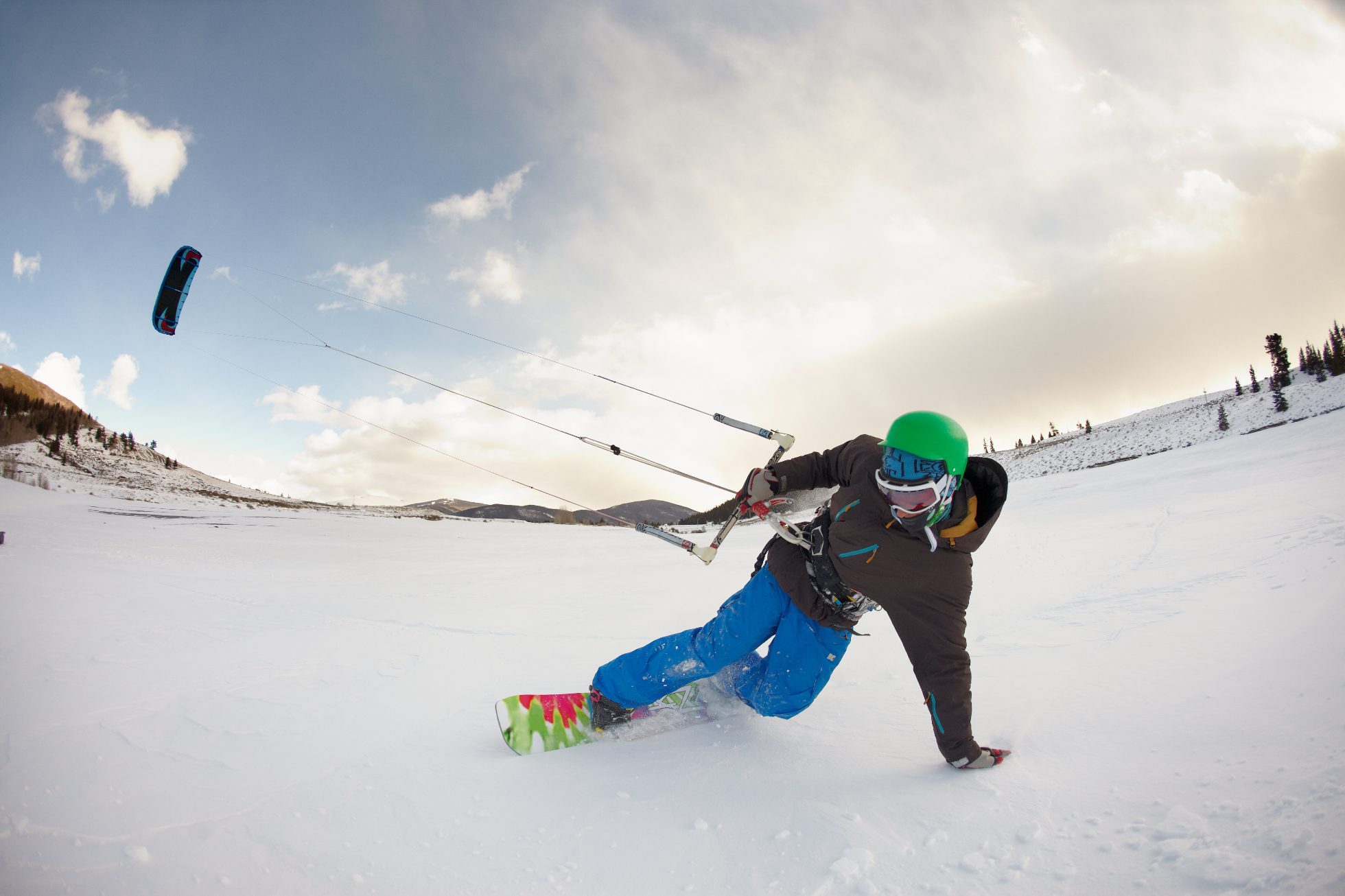 Mężczyzna uprawiający snowkiting w górach, sporty zimowe