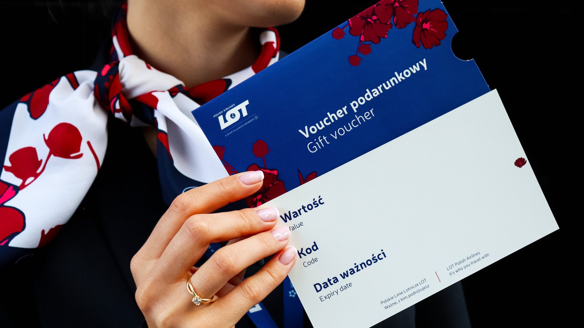 Flight attendant holding a blue-coloured gift voucher