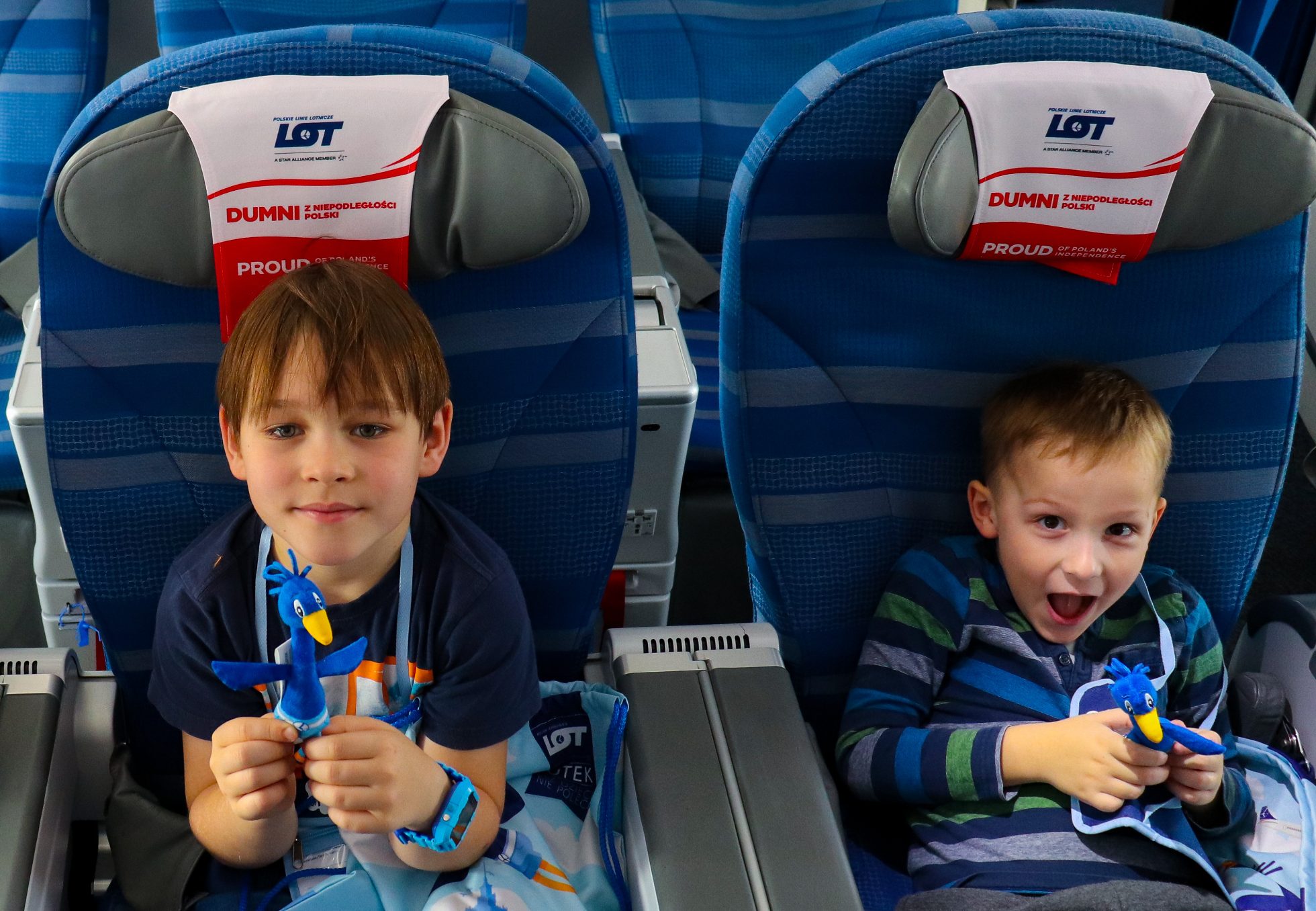 Two boys sitting in seats holding a LOTEK toy in their hands
