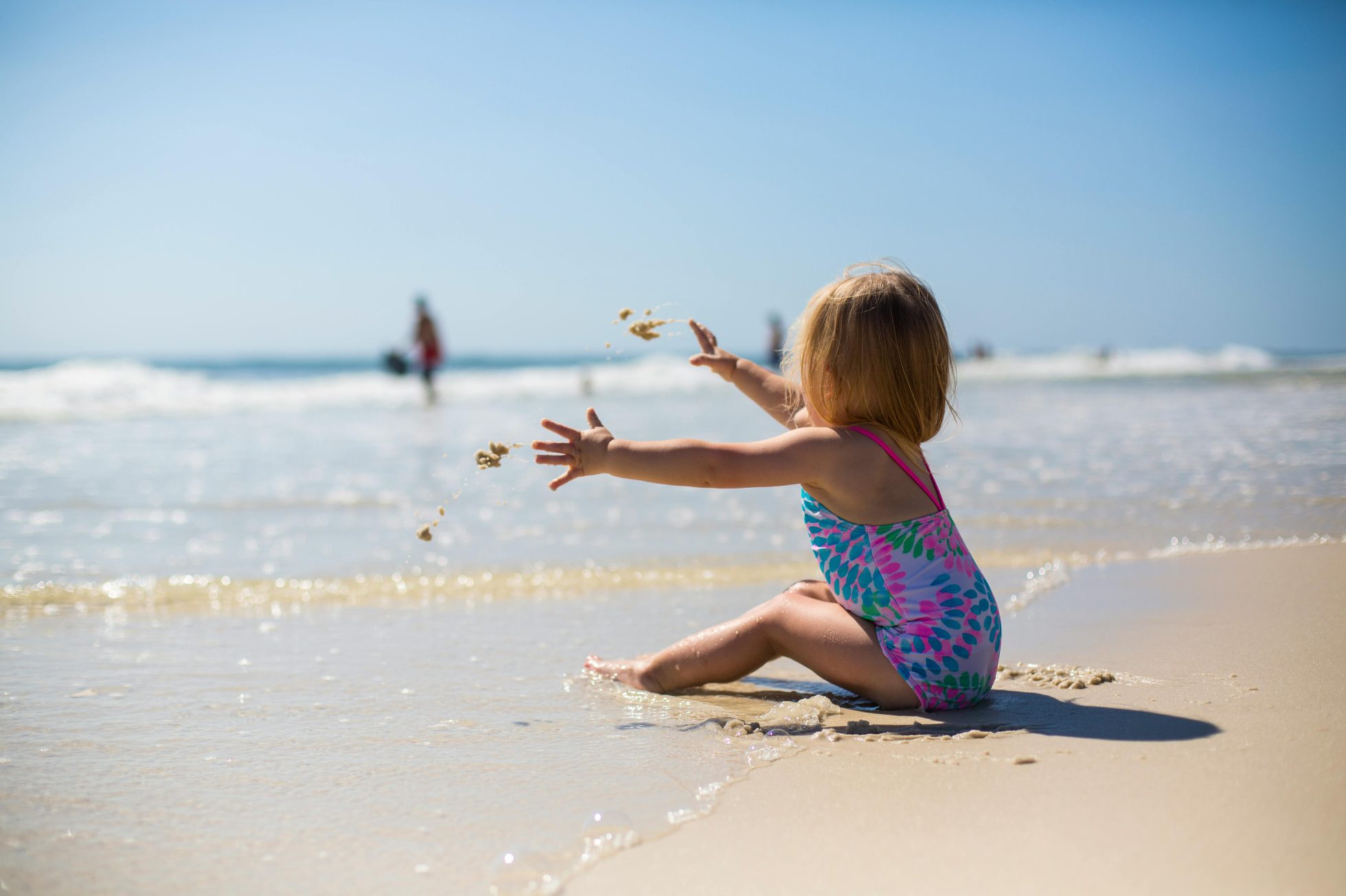 Małe dziecko bawi się piaskiem na plaży