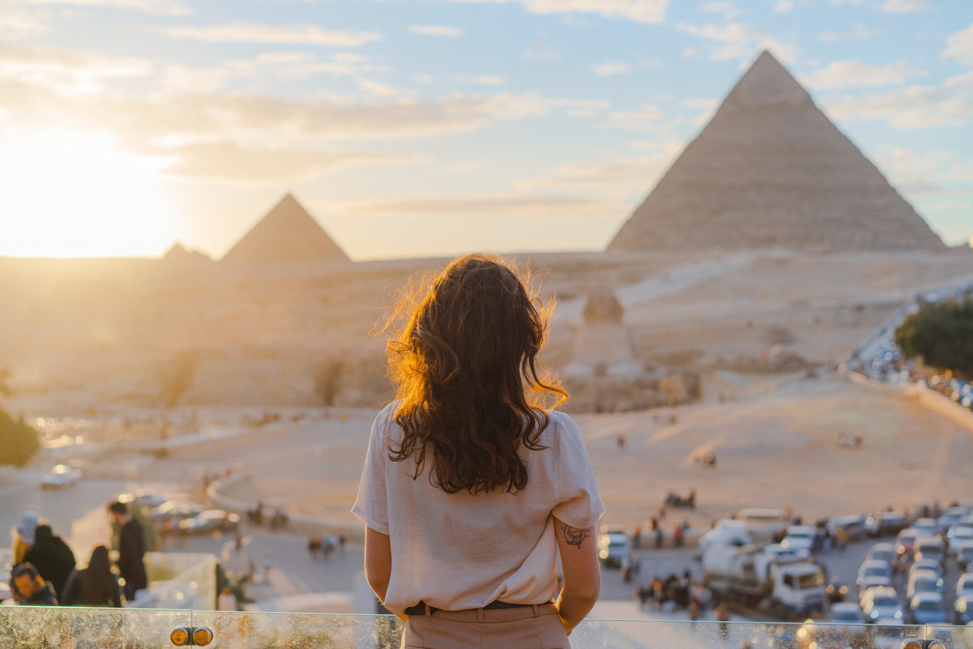 A young tourist admires the pyramids in Egypt at sunset