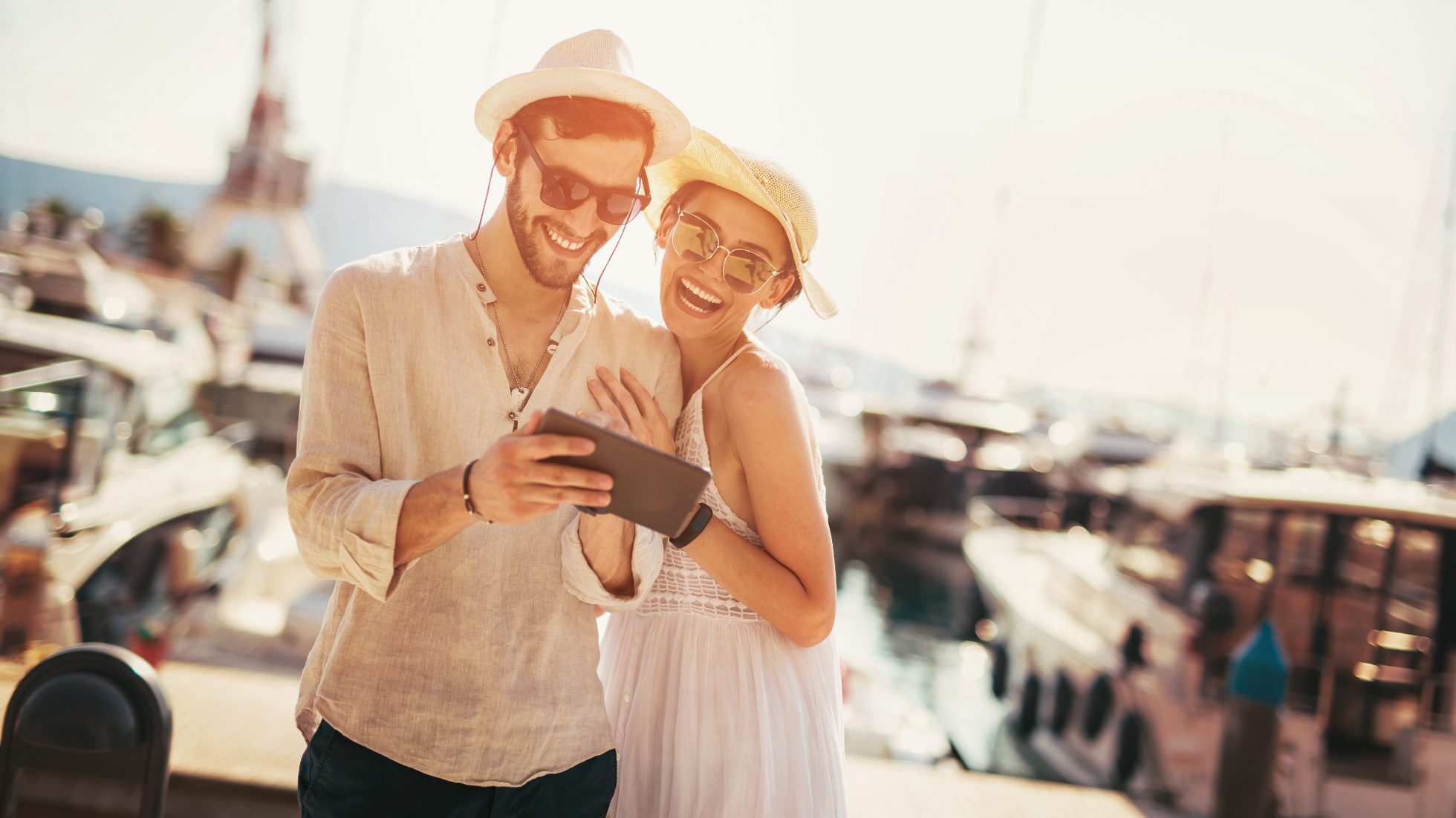 The couple in love seeking through offer on tablet in front of harbor