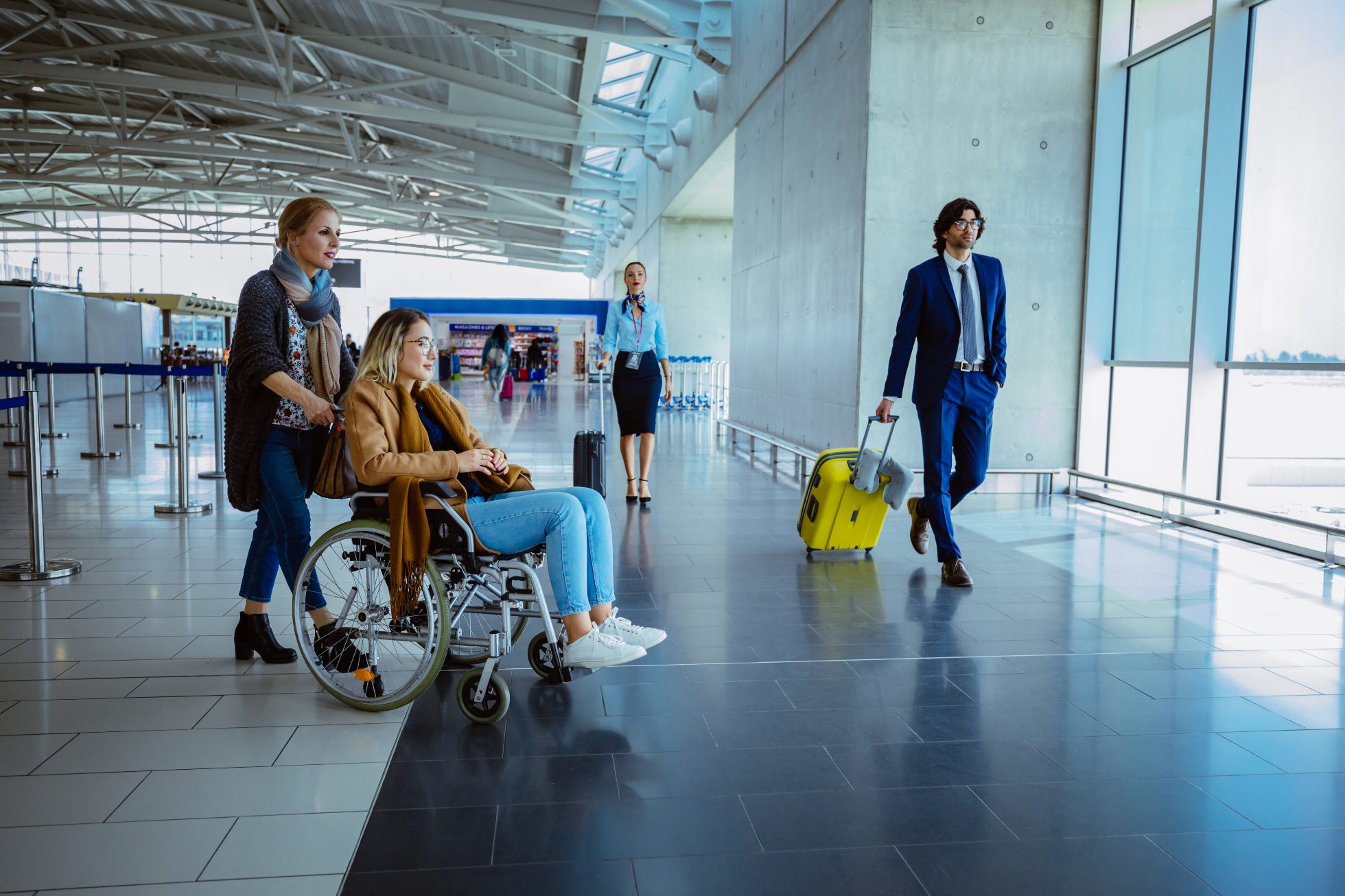Diverse group of passengers walking and standing on international airport corridor with window