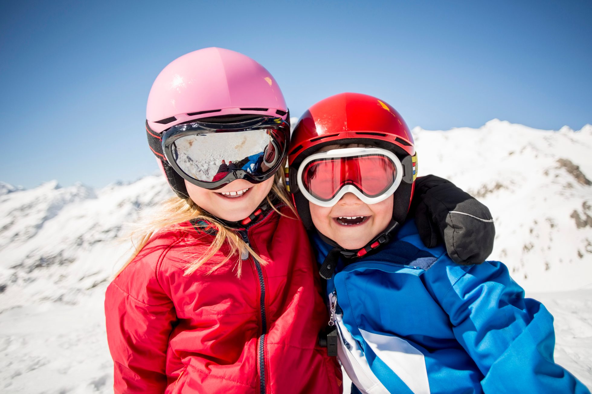 Smiling children dressed in ski outfits