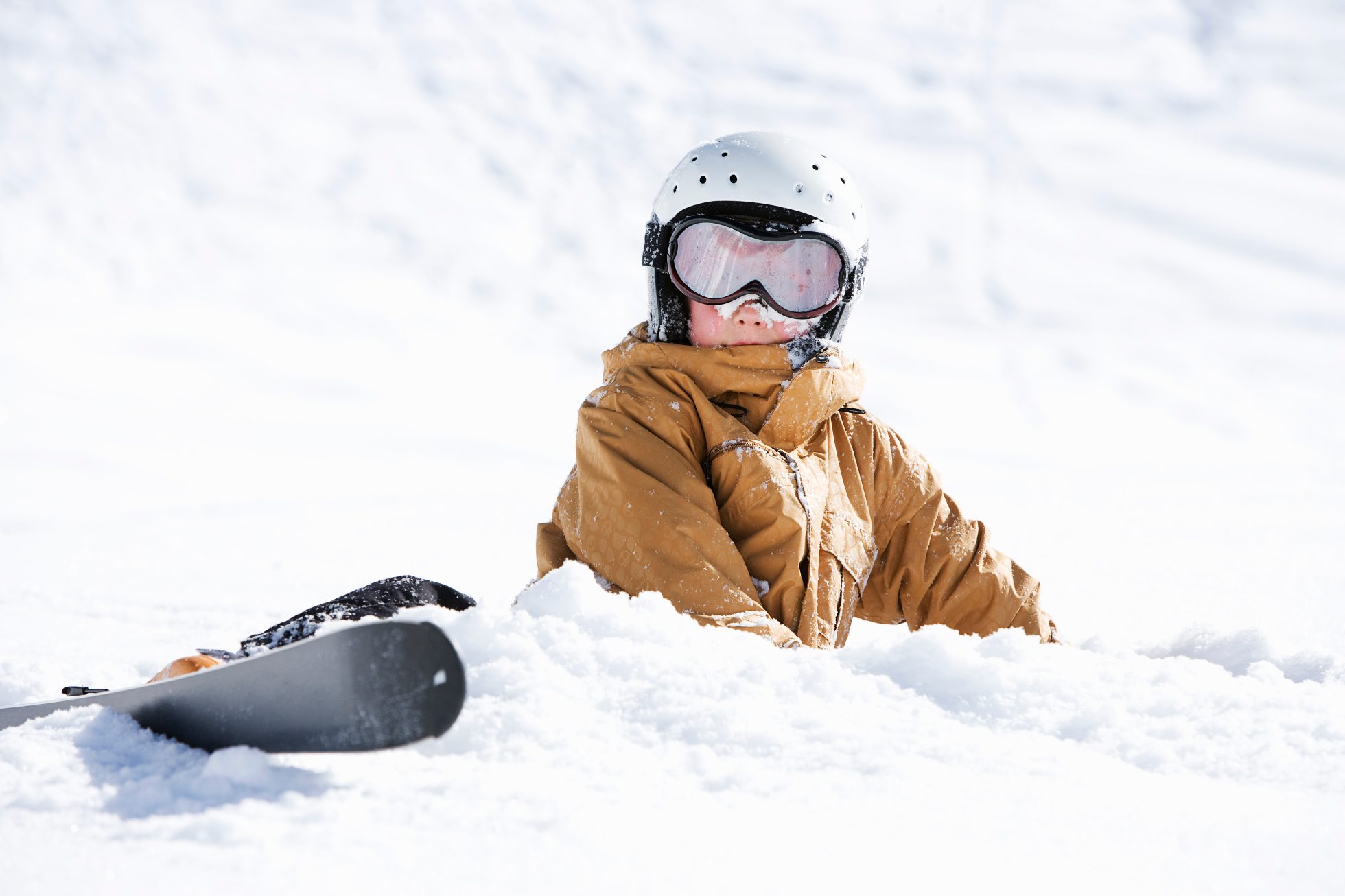 Dziecko na snowboardzie na stoku górskim w zimowej scenerii.