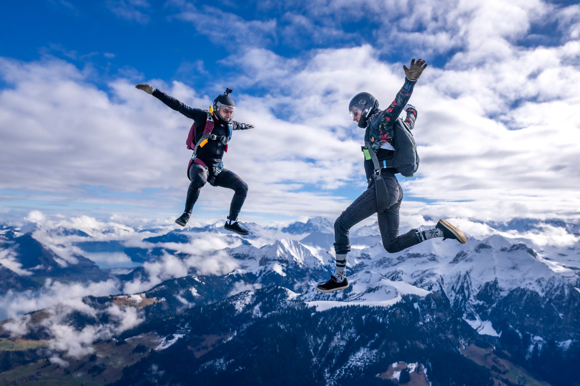 Two people skydiving over mountains in Switzerland