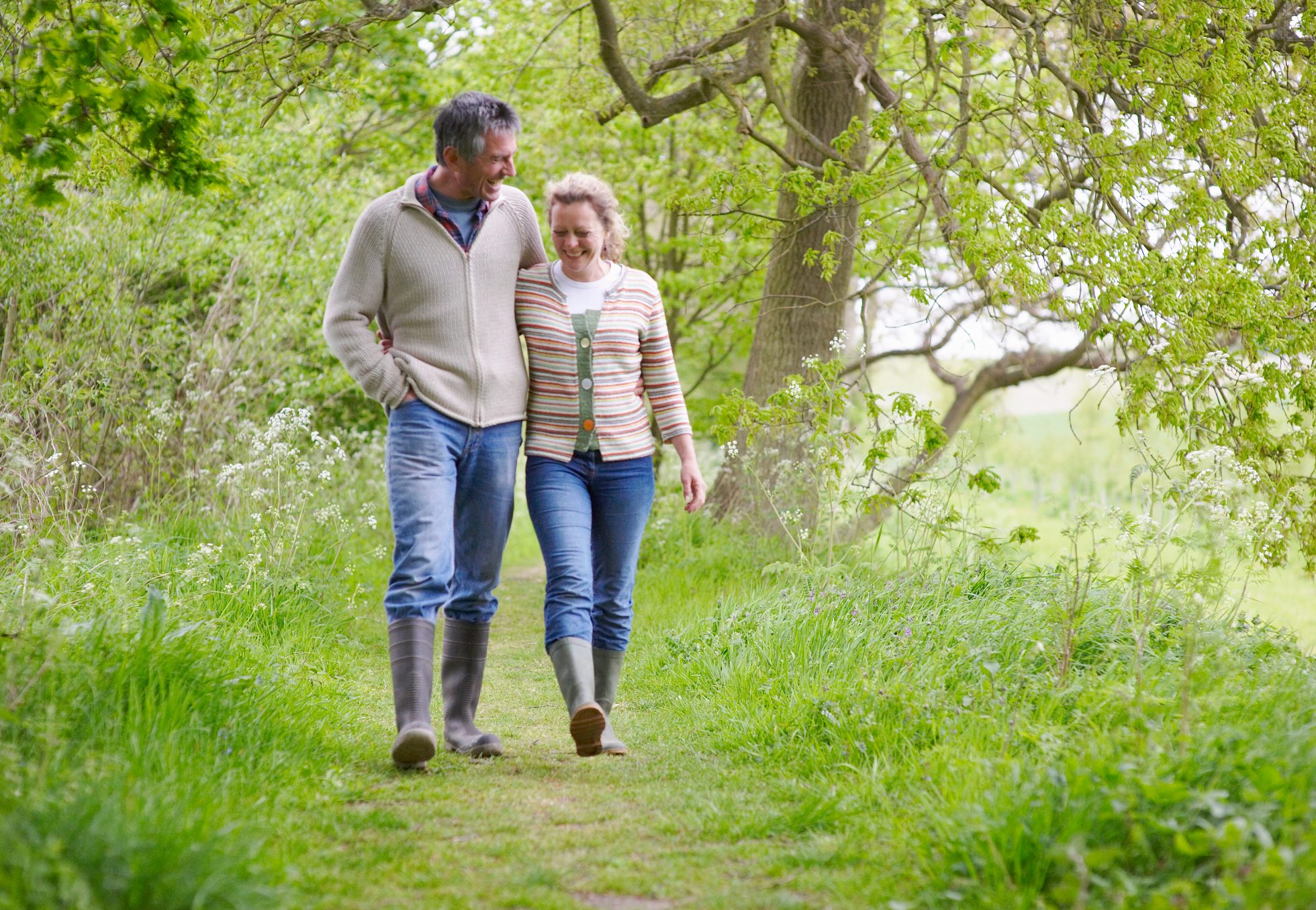 Couple walking through the woods in wellies