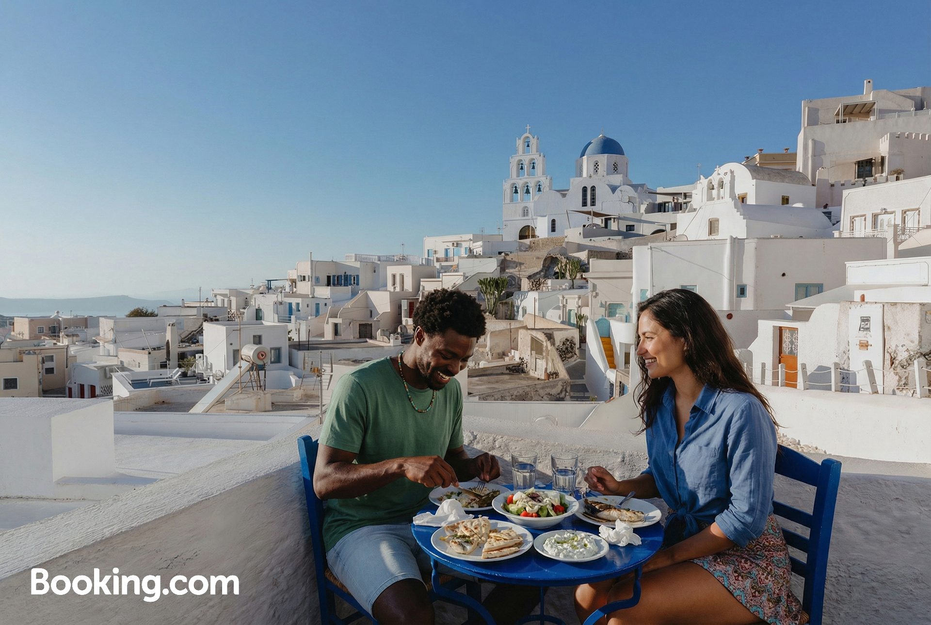 Para jedząca posiłek w hotelu na tarasie z widokiem na greckie miasto.
