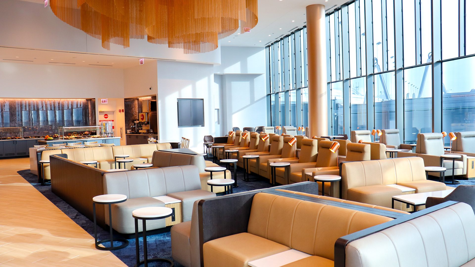 The modern, glass-walled interior of the Business Lounge at Chicago Airport.