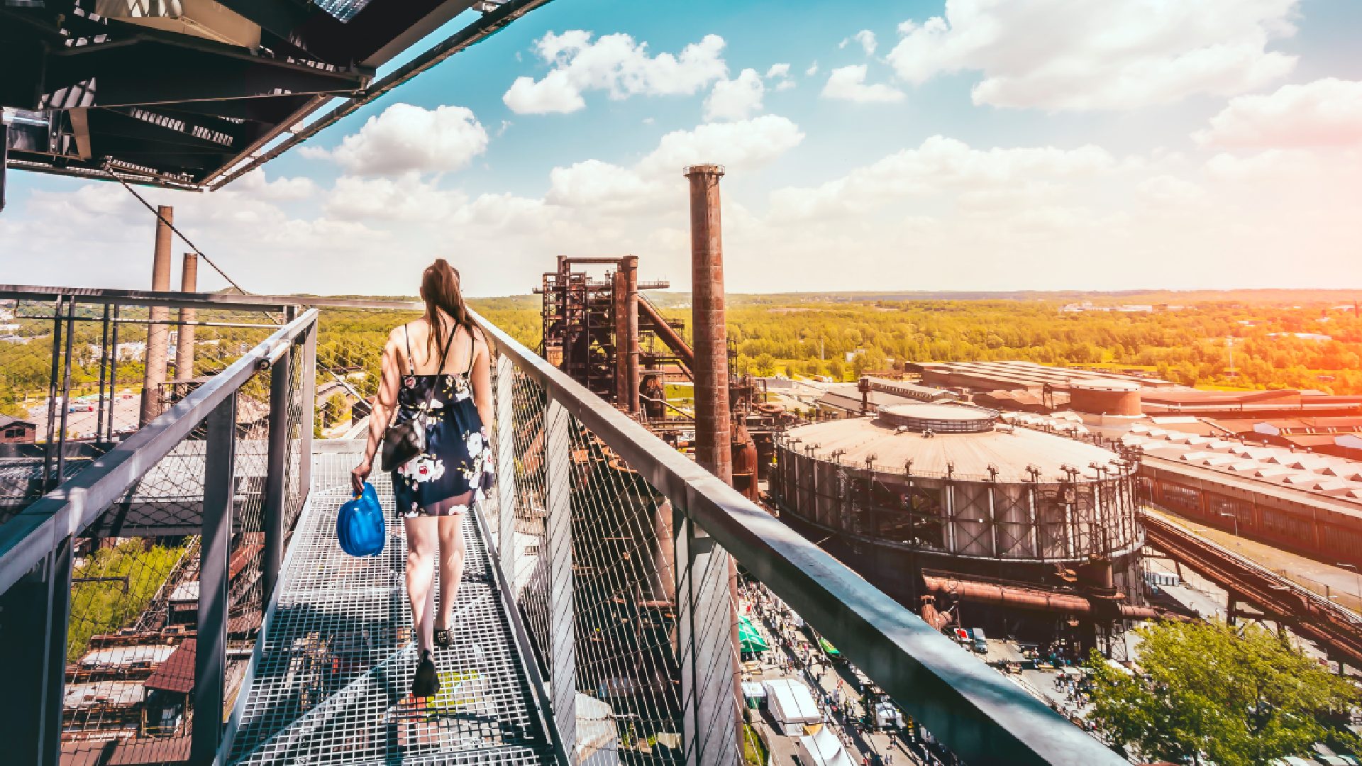 A woman walking around a viewpoint overlooking Gong Hall — a famous round performance venue, formerly a gas tank, located in Lower Vítkovice.