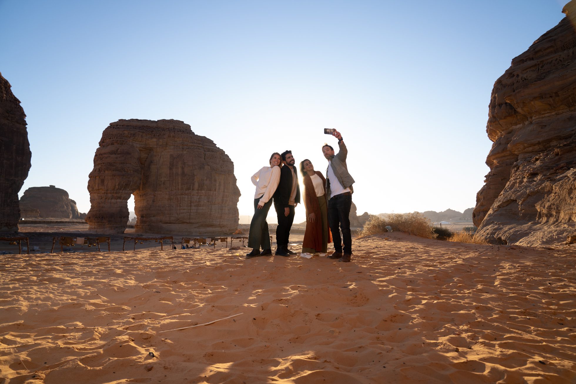 Tourists taking a photo against the backdrop of the rocks in AlUla