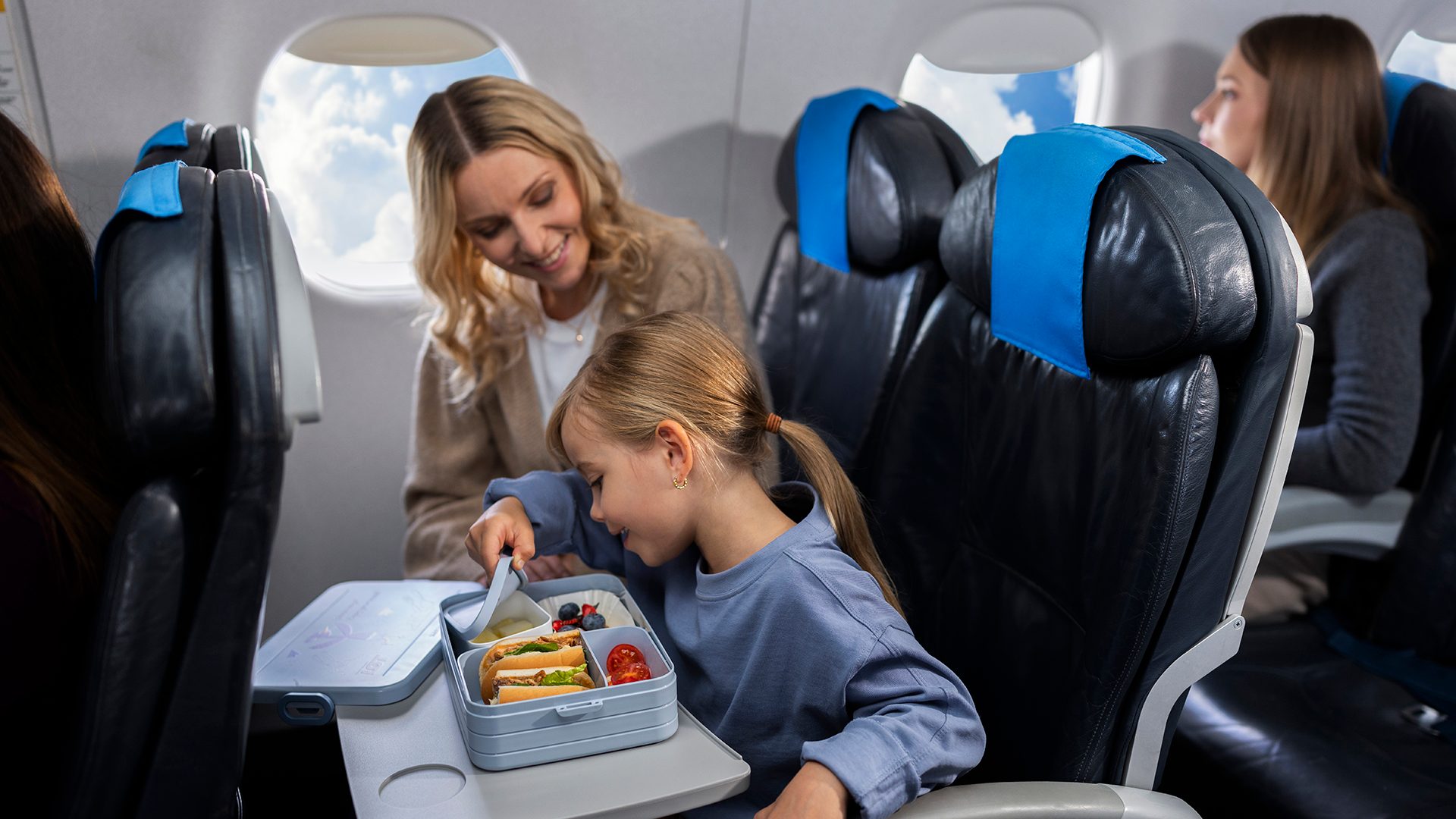 Child on board Embraer eats meal from LOT lunch box