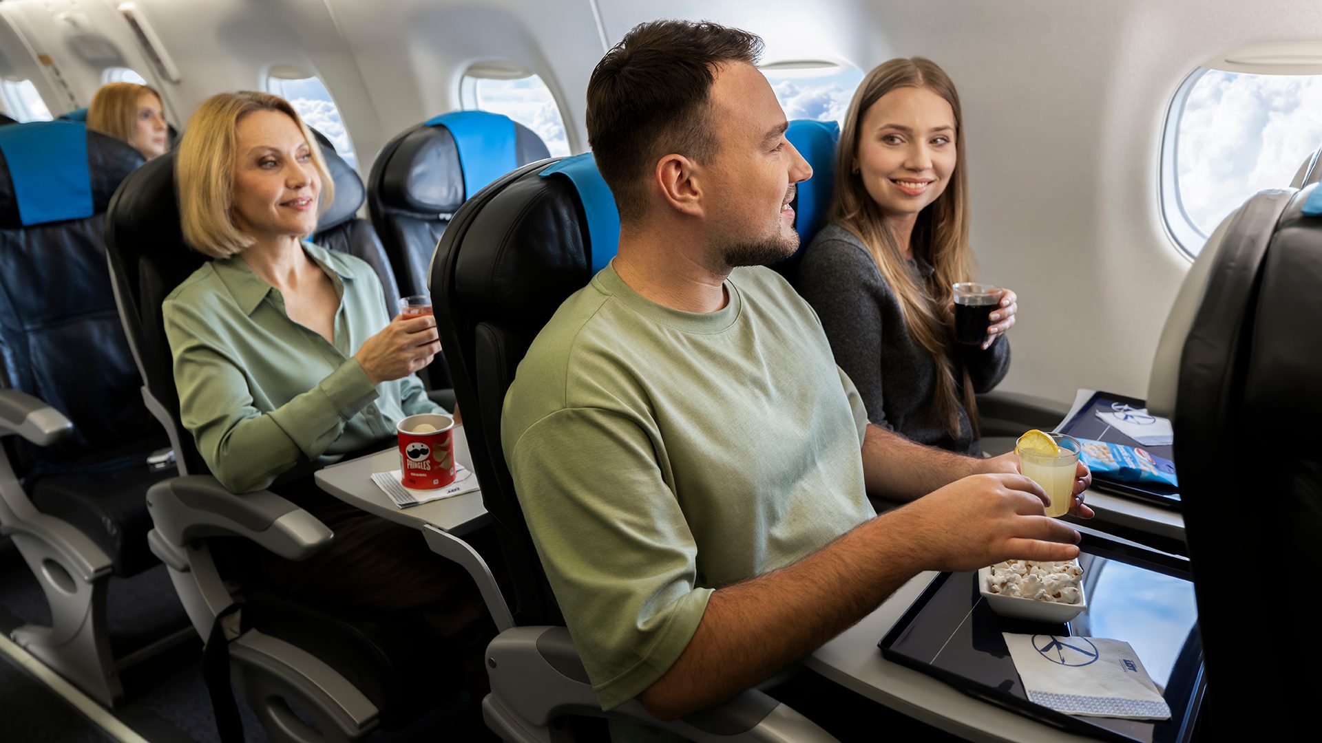 Passengers are eating snacks while traveling on Embraer aircraft