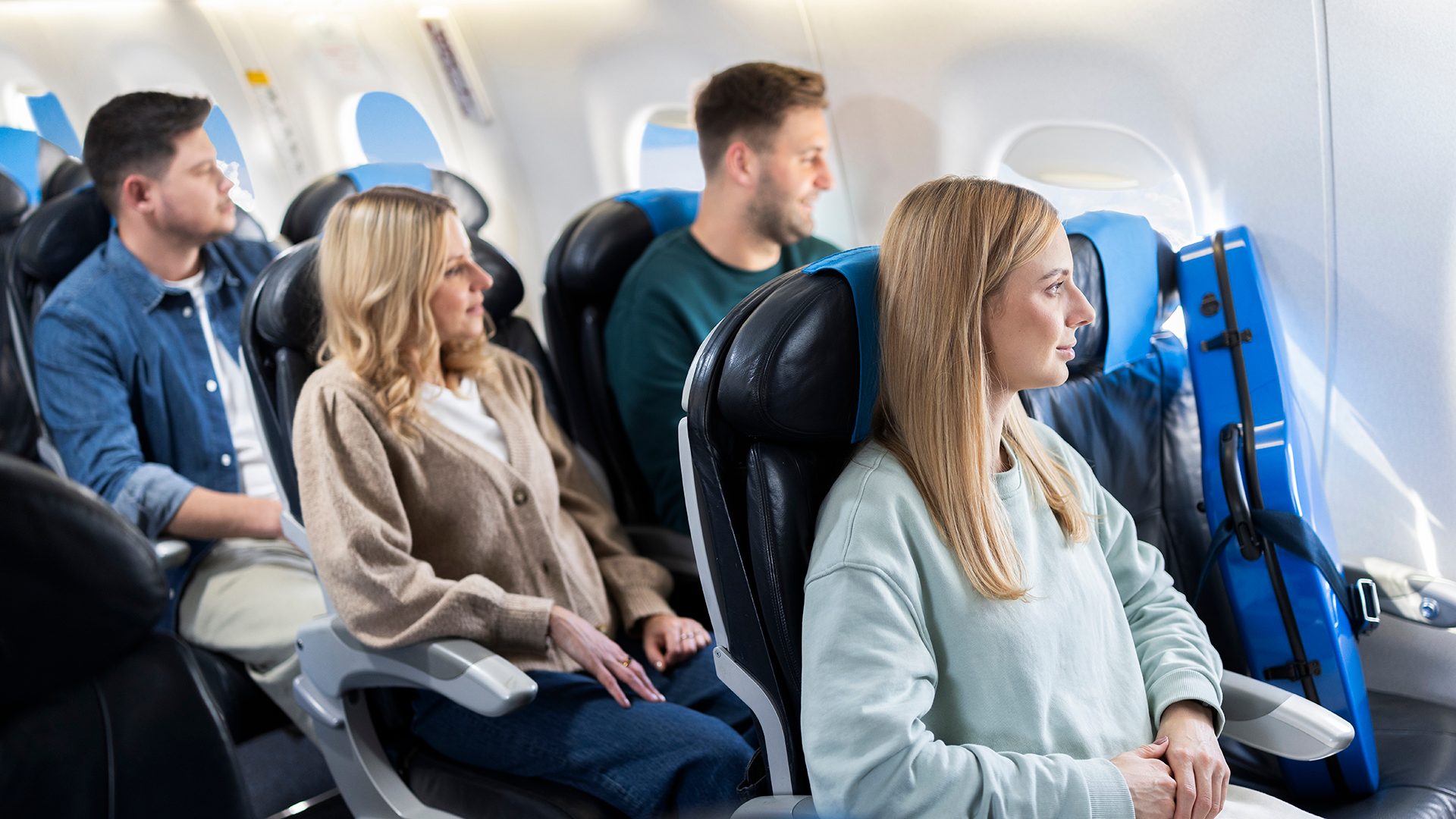 A passenger with a musical instrument occupies two seats onboard an Embraer.