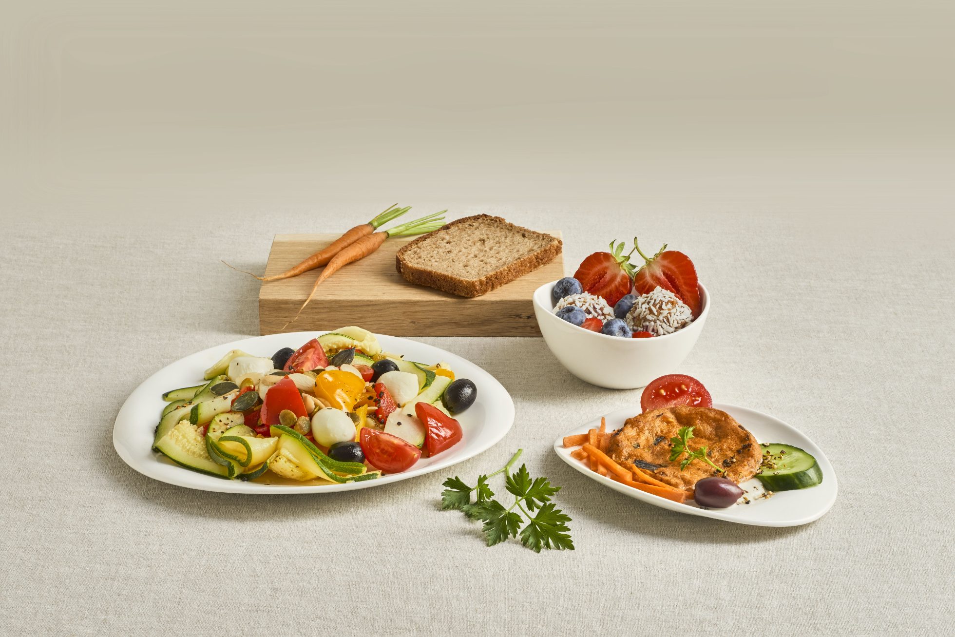 The image shows a vegetarian meal consisting of bread, salad, vegetables, and fruits.